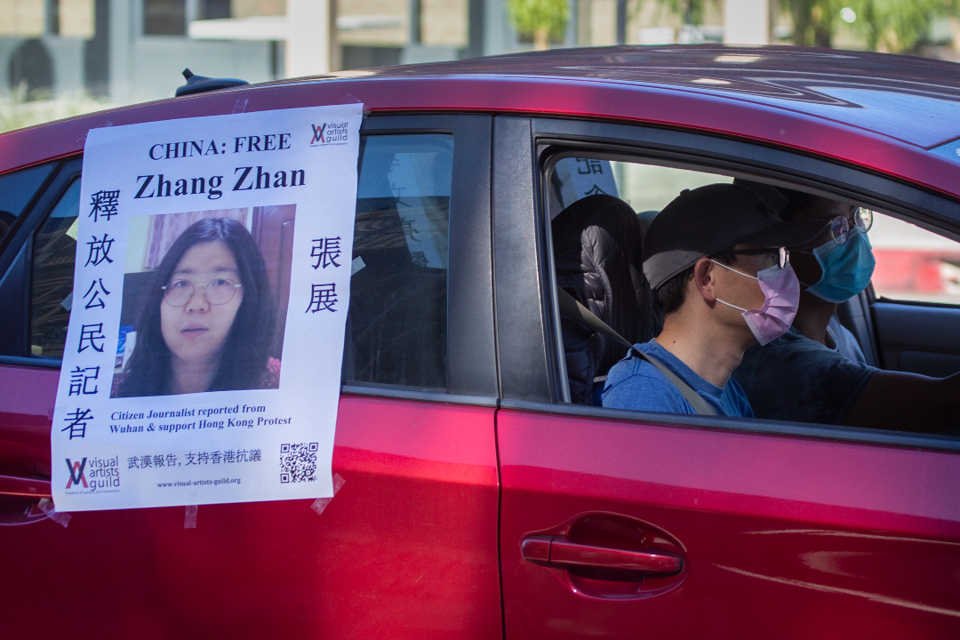 2020年11月15日，美国加州帕萨迪纳（Pasadena），一辆汽车跟在疫情送葬车队后，贴海报呼吁释放中国公民记者张展。摄：Allen J. Schaben/Getty Images