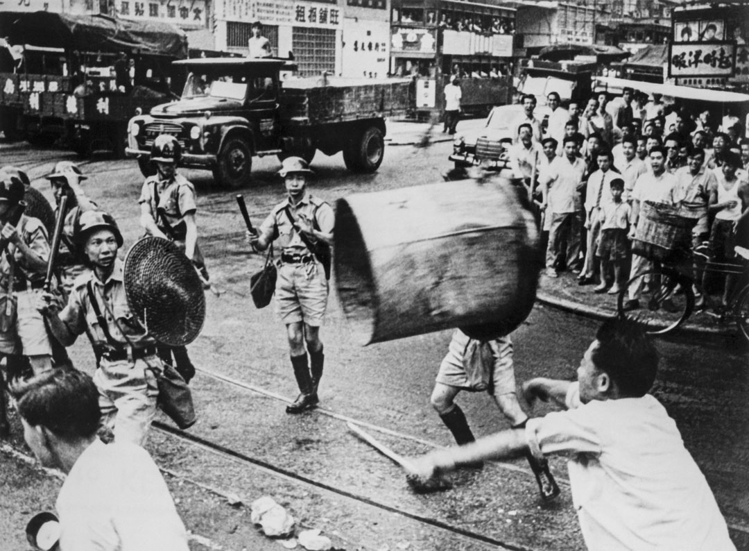 1967年6月，六七暴動期間，一名男子在街頭向警察扔垃圾桶。