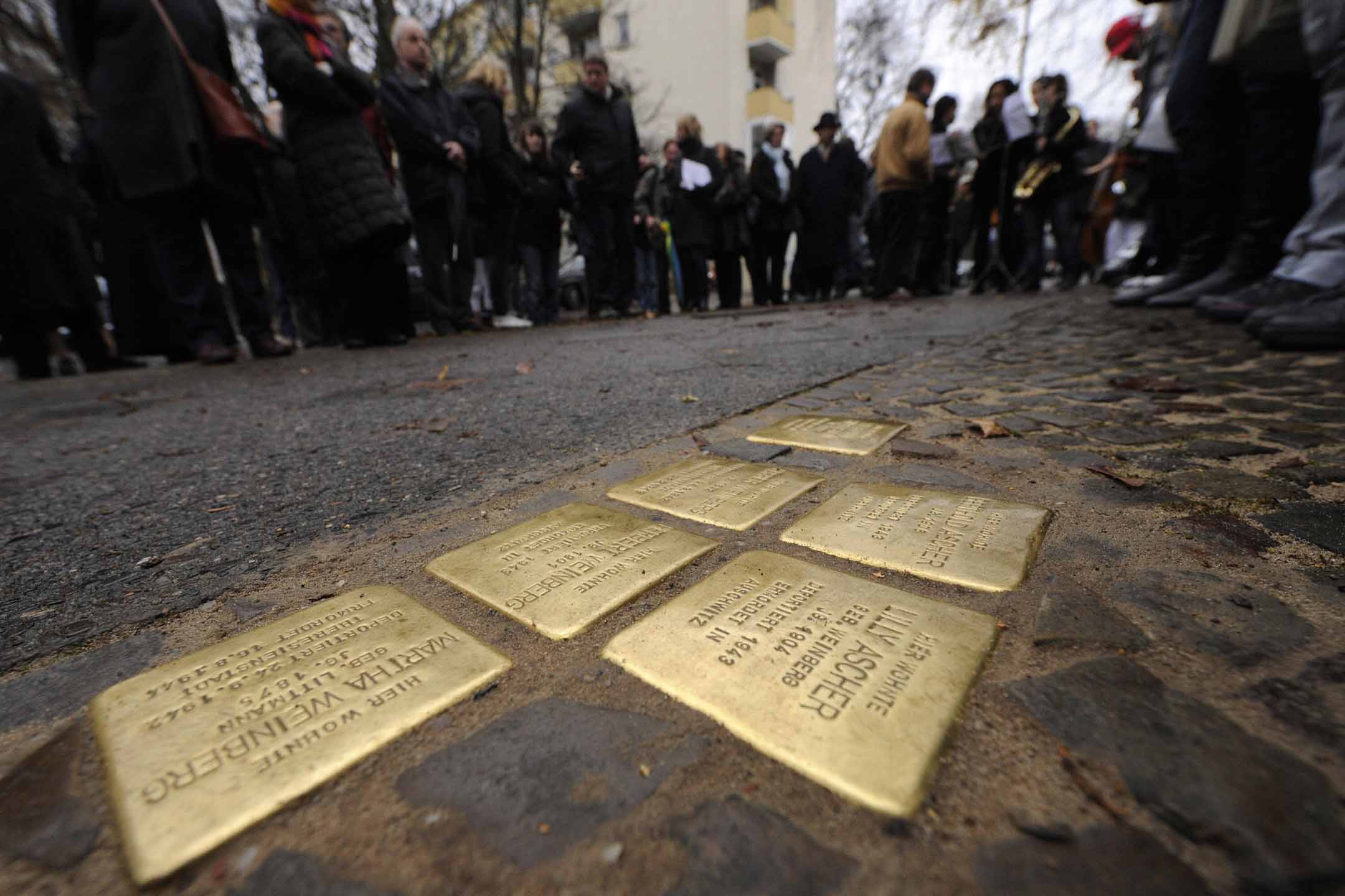 2008年11月26日柏林克羅伊茨貝格區，人們站在“絆腳石”(Stolpersteine)周圍。 