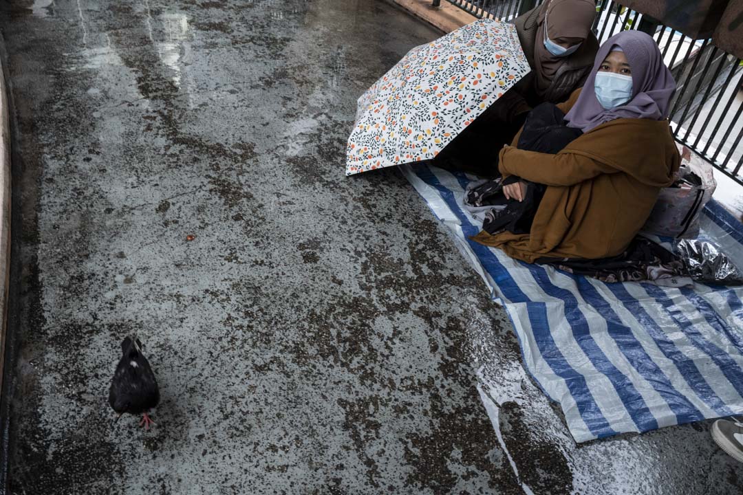 2022年2月20日，两位移工于严寒又下雨的情况之下，在铜锣湾的天桥上休息。