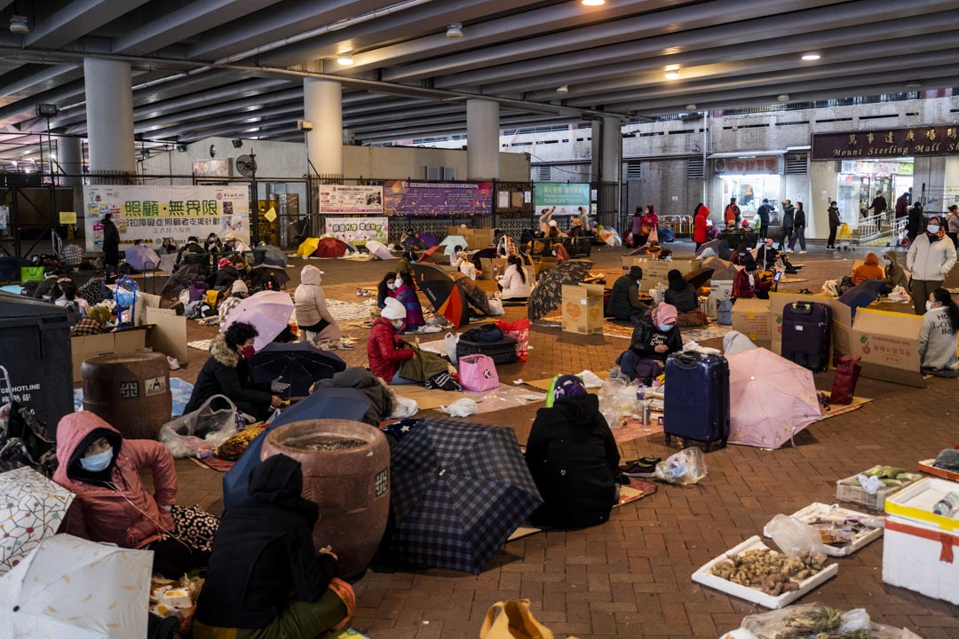 2022年2月20日，美孚地铁站附近一个天桥下，移工在限聚令下二人一组休息。