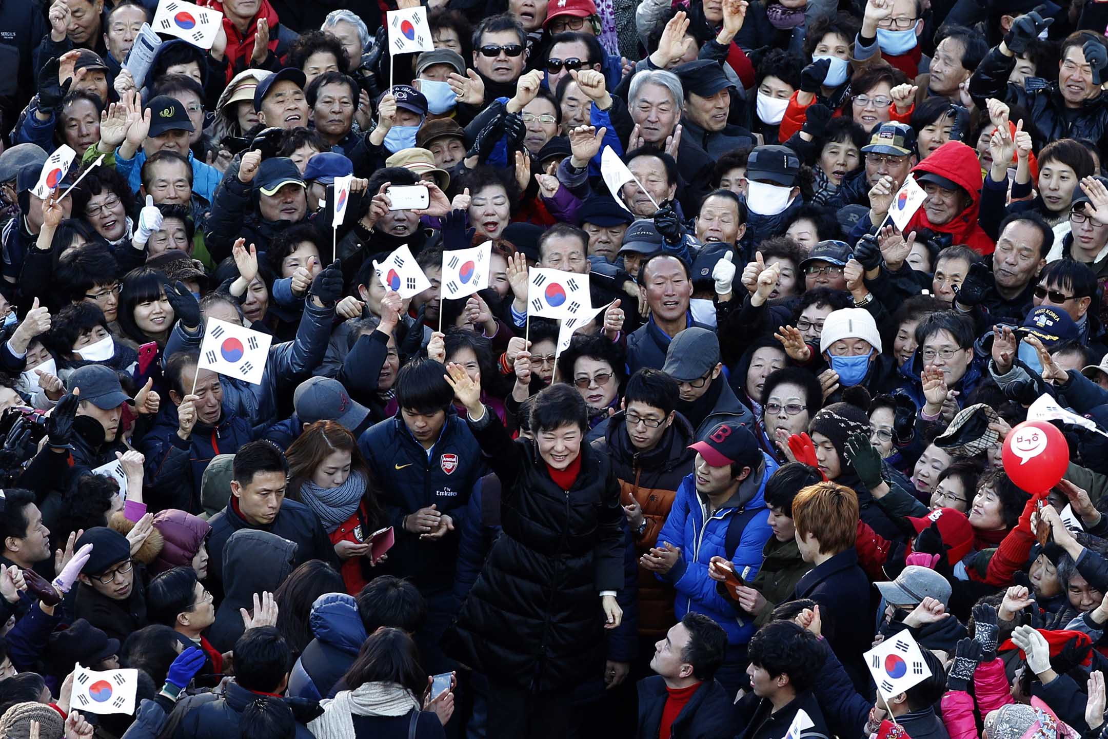 2012年12月18日，首尔的釜山火车站前举行的竞选集会上，韩国总统候选人朴槿惠向支持者挥手致意。