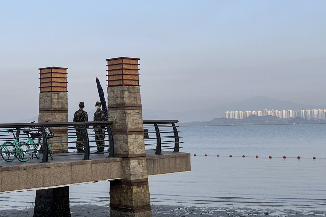 深圳湾公园的海边有身着军装的军人站岗。