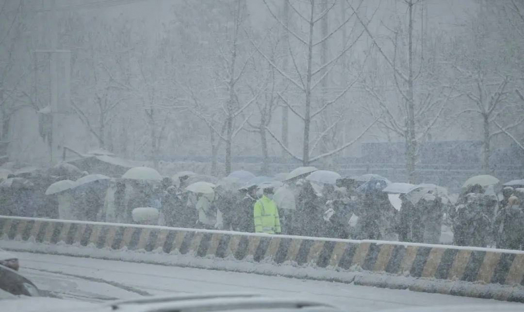 居民在大雪中排队等待进入燕郊。