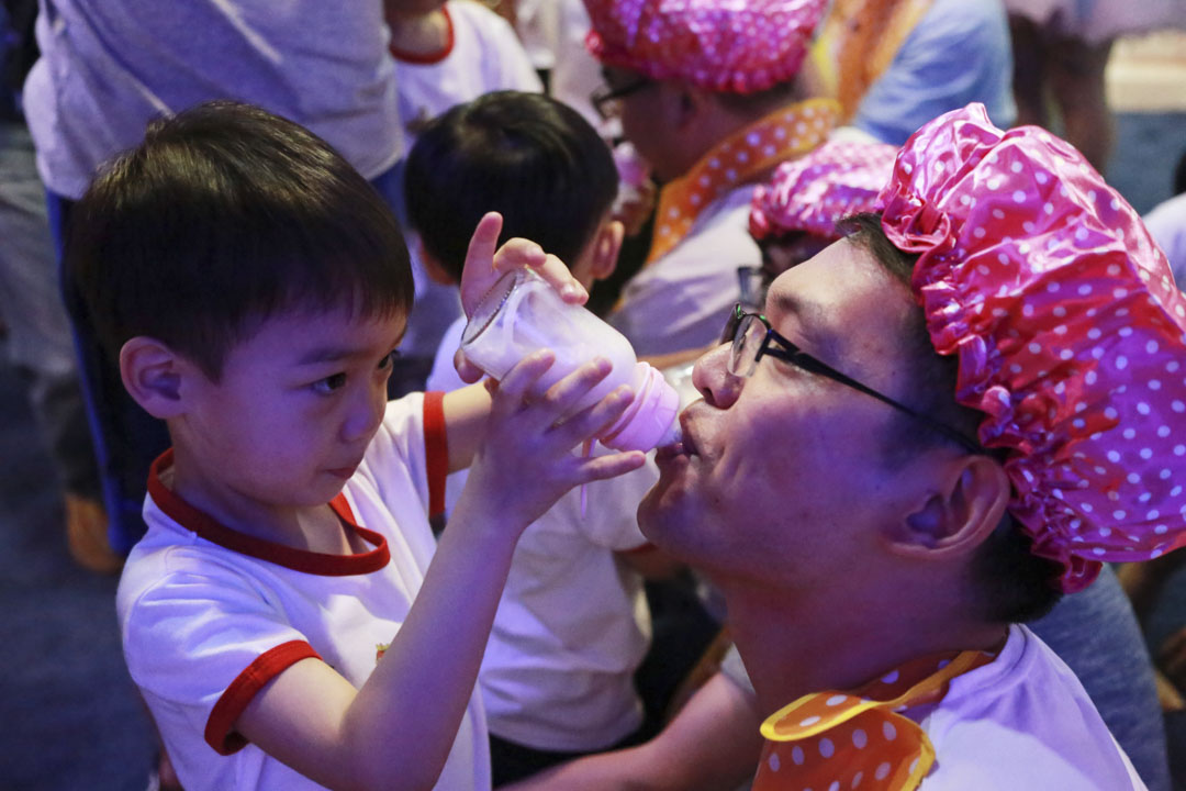 2016年6月19日，中國杭州，孩子們用奶瓶餵父親喝牛奶，慶祝父親節。