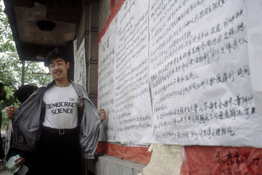 1989年5月11日，北京大学民主墙，吾尔开希展示写着“民主科学”的衬衫。