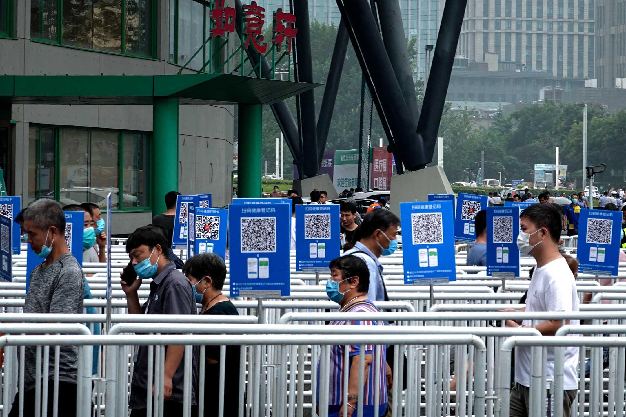 2020年8月5日，郑州，郑州食品博览会上，戴著口罩的人们排队接受体温检测。