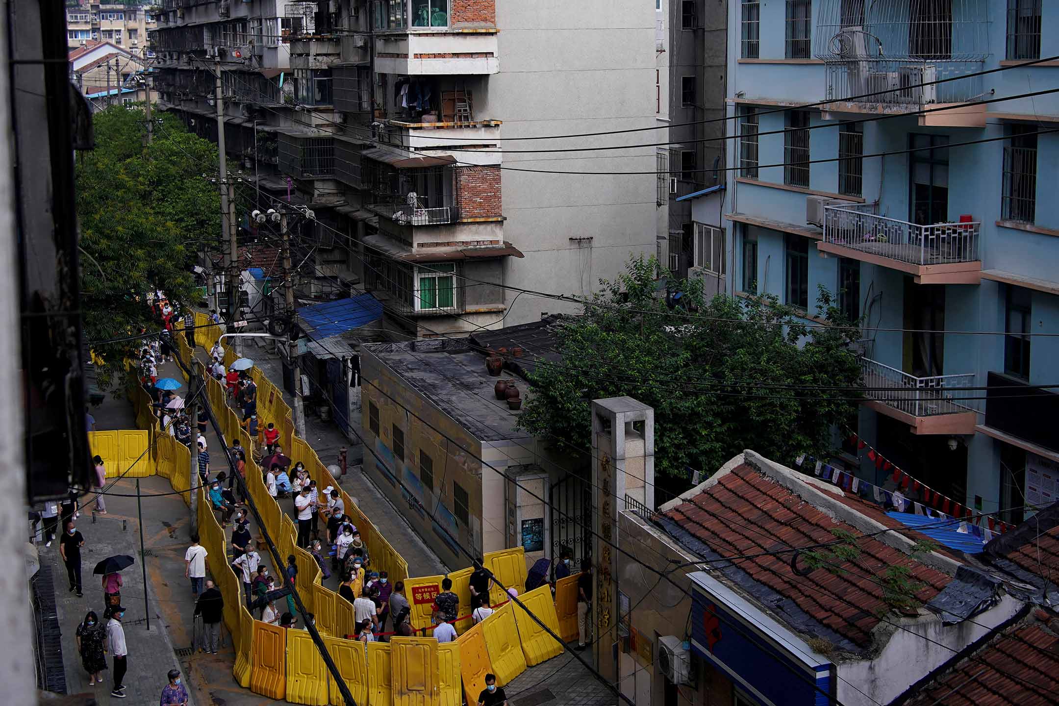 2020年5月17日，武汉市民戴著口罩在一个住宅区排队接受核酸检测。