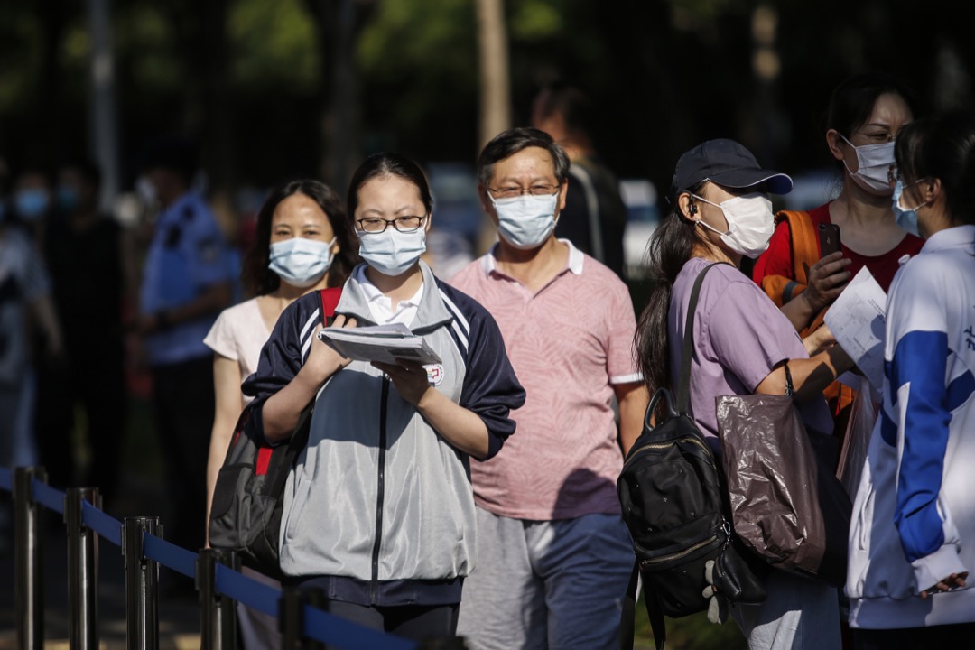 2020年7月，中国首都北京，家长陪同子女前往高考考场。