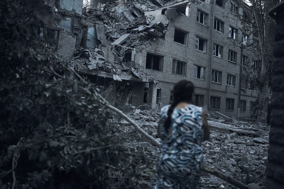 2022年8月2日，烏克蘭 Mykolaiv 發生夜間砲擊後，一名婦女走在住宅樓的廢墟中。