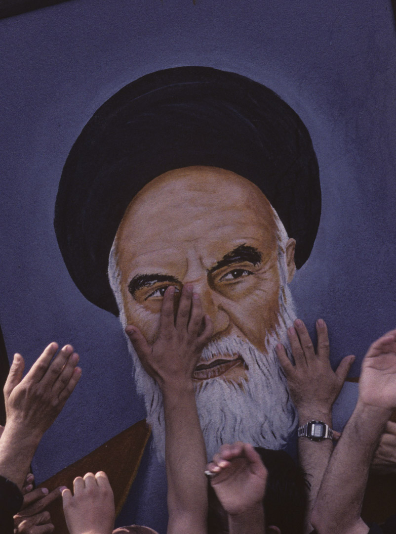 1989年6月5日，伊朗德黑兰，哀悼者伸手触摸阿亚图拉·霍梅尼 (Ayatollah Khomeini) 的肖像。