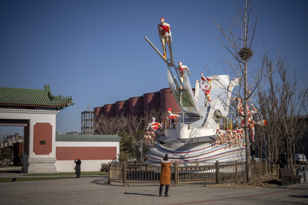 2022年1月，中国北京，一名游客在首钢改建成的冬奥大跳台项目比赛场地外拍照。