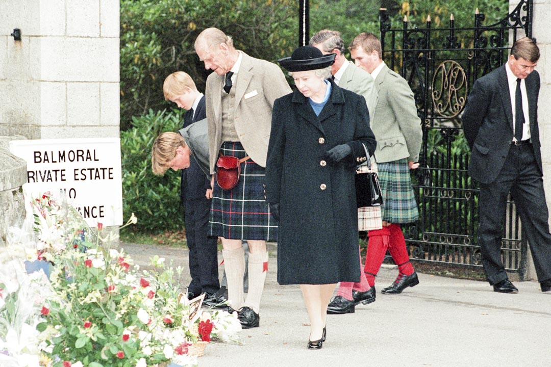 1997年9月5日，苏格兰巴尔莫勒尔庄园，英国王室成员在巴尔莫勒尔城堡的大门前，停下来看民众悼念戴安娜王妃的鲜花。