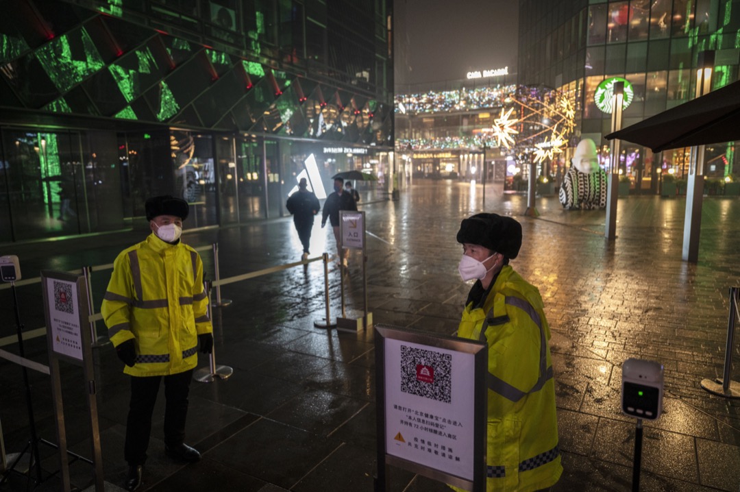 2022年11月20日，中国北京，两名保安员在一个购物区外看守，进内的市民需要扫描“北京健康宝”二维码。