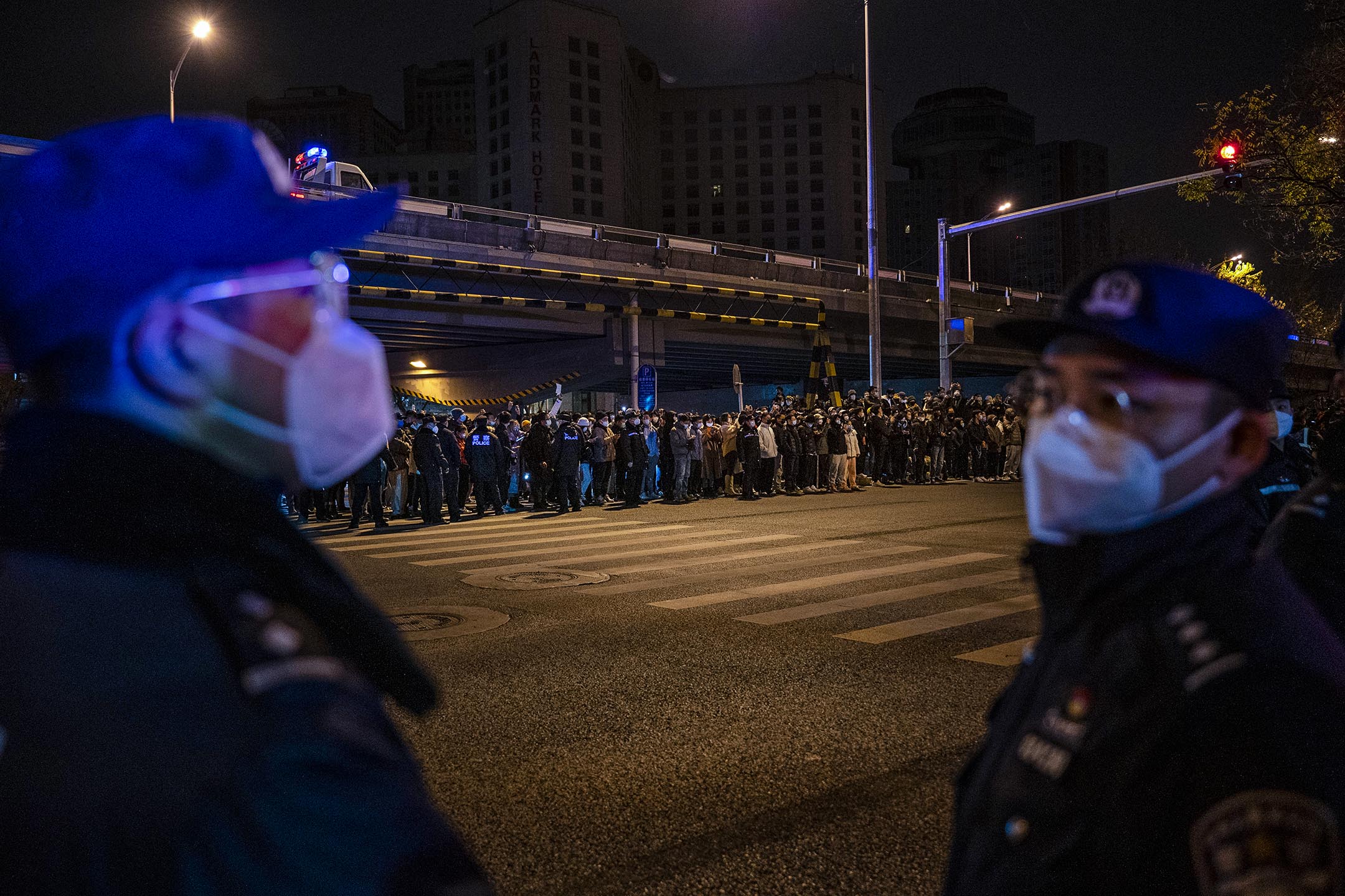 2022年11月28日，北京，抗议中国政府清零政策期间，警察站在示威者对面。