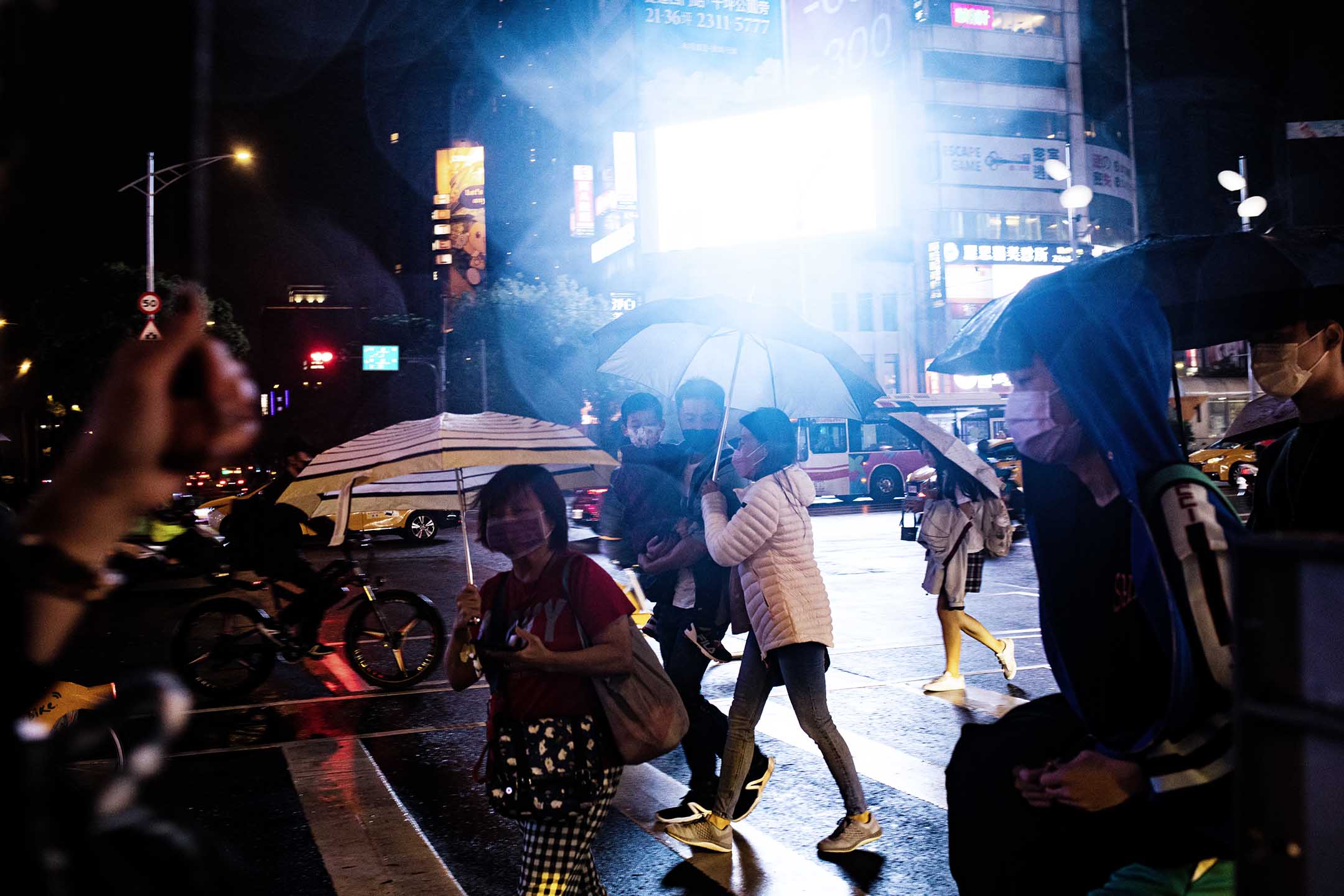 2022年10月22日，台北，市民在雨中横过马路。