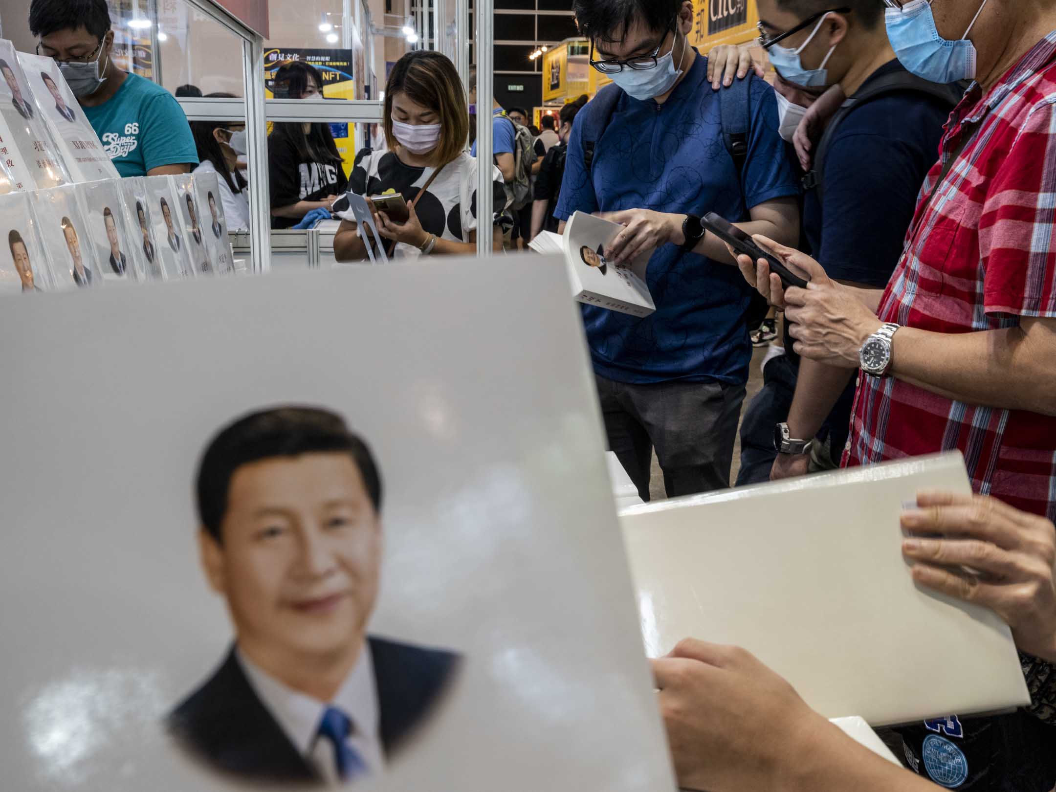 2022年7月22日，香港书展有不少书商都在宣传架上摆放了《习近平谈治国理政》，市民站著在档位阅读。摄：林振东/端传媒 