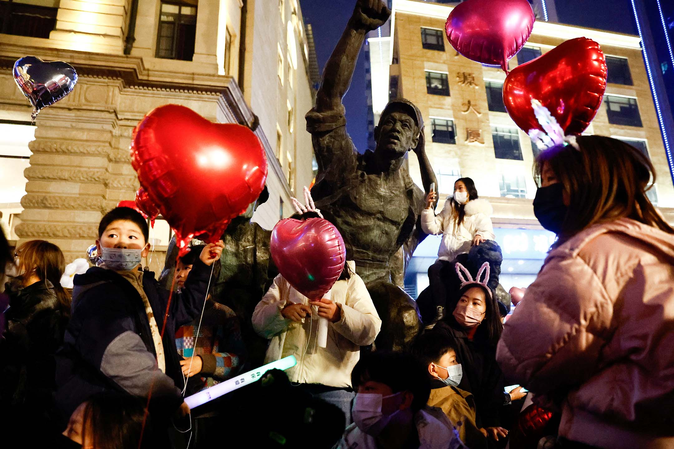 2022年12月31日，湖北省武汉市，疫情期间，人们聚集在一起庆祝新年并举著气球。