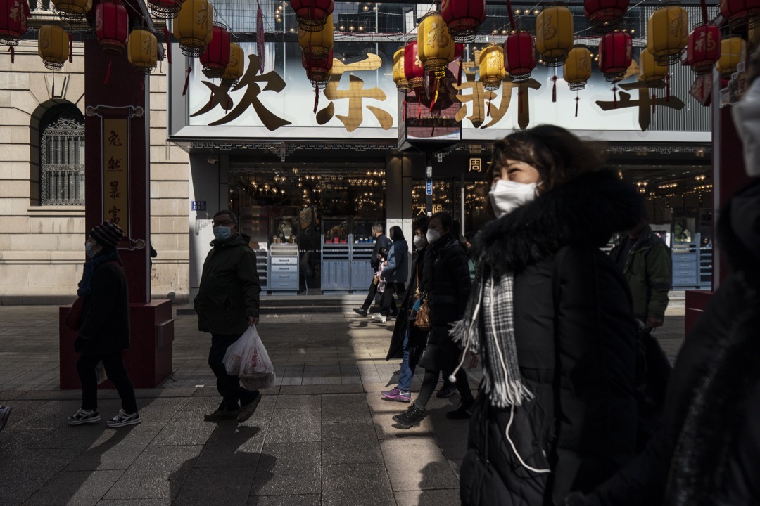 2023年1月25日，中國蘇州，戴口罩的市民在農曆新年期間在一條商業街走過。