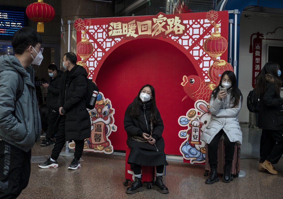 2023年1月20日，中国北京，一名女子坐在一个以新年为主题的背景前面。