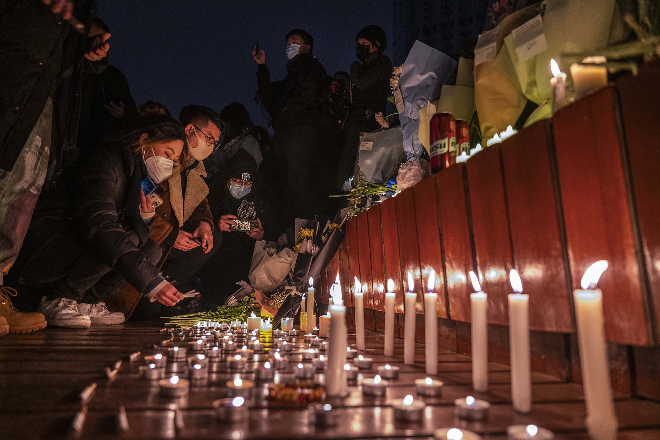 2022年11月27日，北京，为悼念乌鲁木齐大火死难者，市民在追悼期间点燃蜡烛。