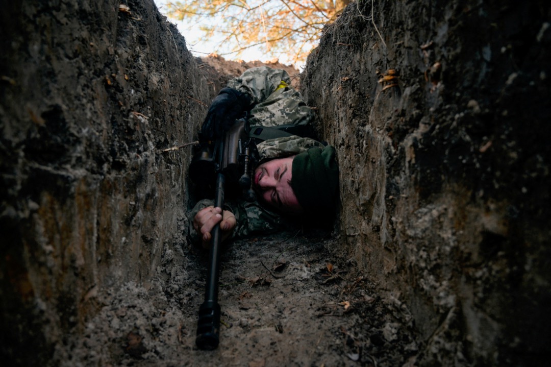 2022年3月10日，烏克蘭首都基輔近郊小鎮德米迪夫（Demydiv），一名烏軍士兵在戰壕裏躲避俄軍直升機的空襲。該照片攝影師於同年4月1日在鄰近小鎮被發現死亡，調查稱他遭俄軍槍殺。