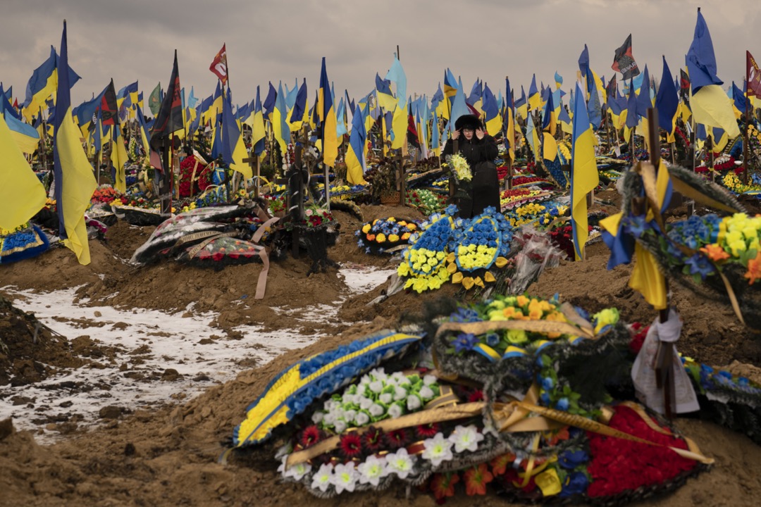 2023年2月16日，乌克兰哈尔科夫，一名女子在一个阵亡士兵墓地中走过。