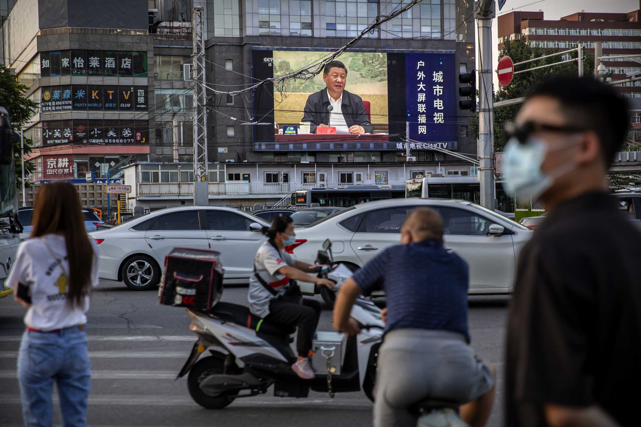 2020年6月30日，国家主席习近平在北京发表讲话时，戴着口罩的人们等待穿过十字路口。摄：Mark Schiefelbein/AP/达志影像