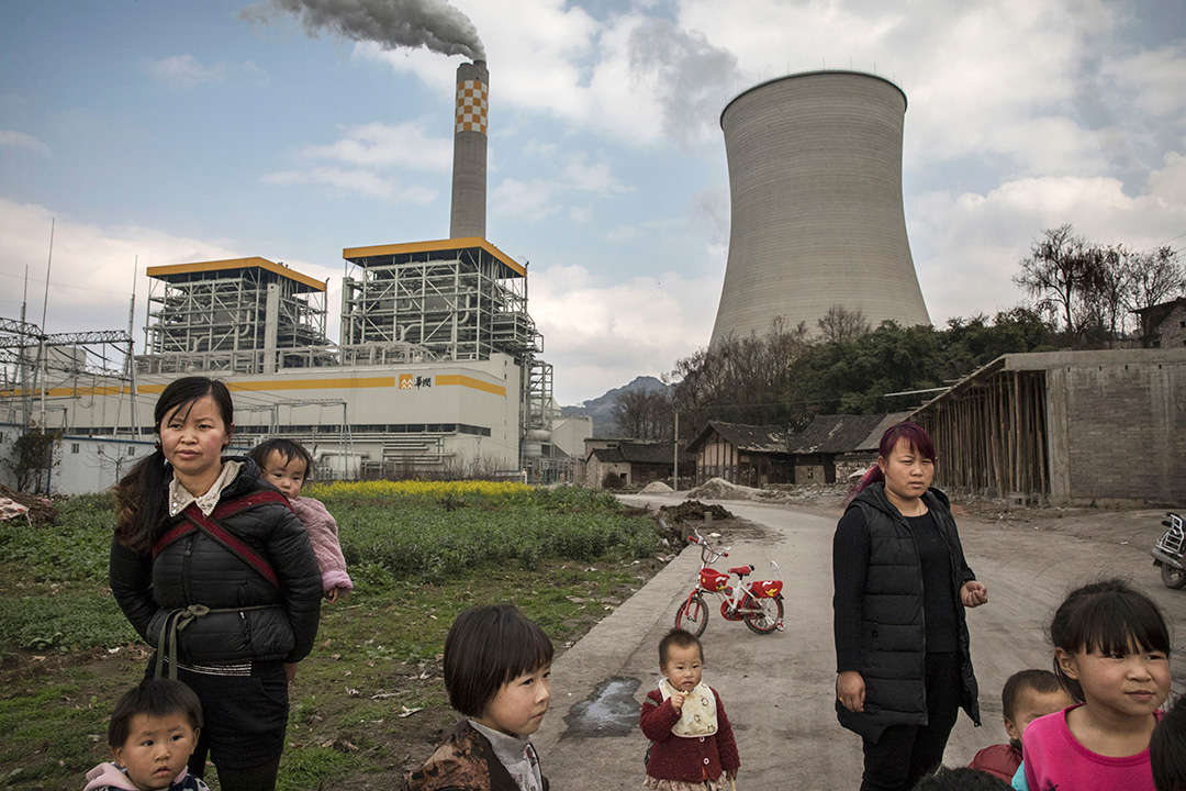 2017年2月7日，中国六盘水市，村民站在燃煤发电厂前。摄：Kevin Frayer/Getty Images