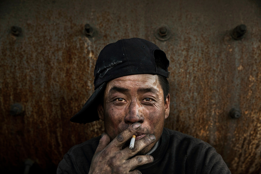 2016年11月3日，中国内蒙古，一名工人在休息时抽烟。摄：Kevin Frayer/Getty Images