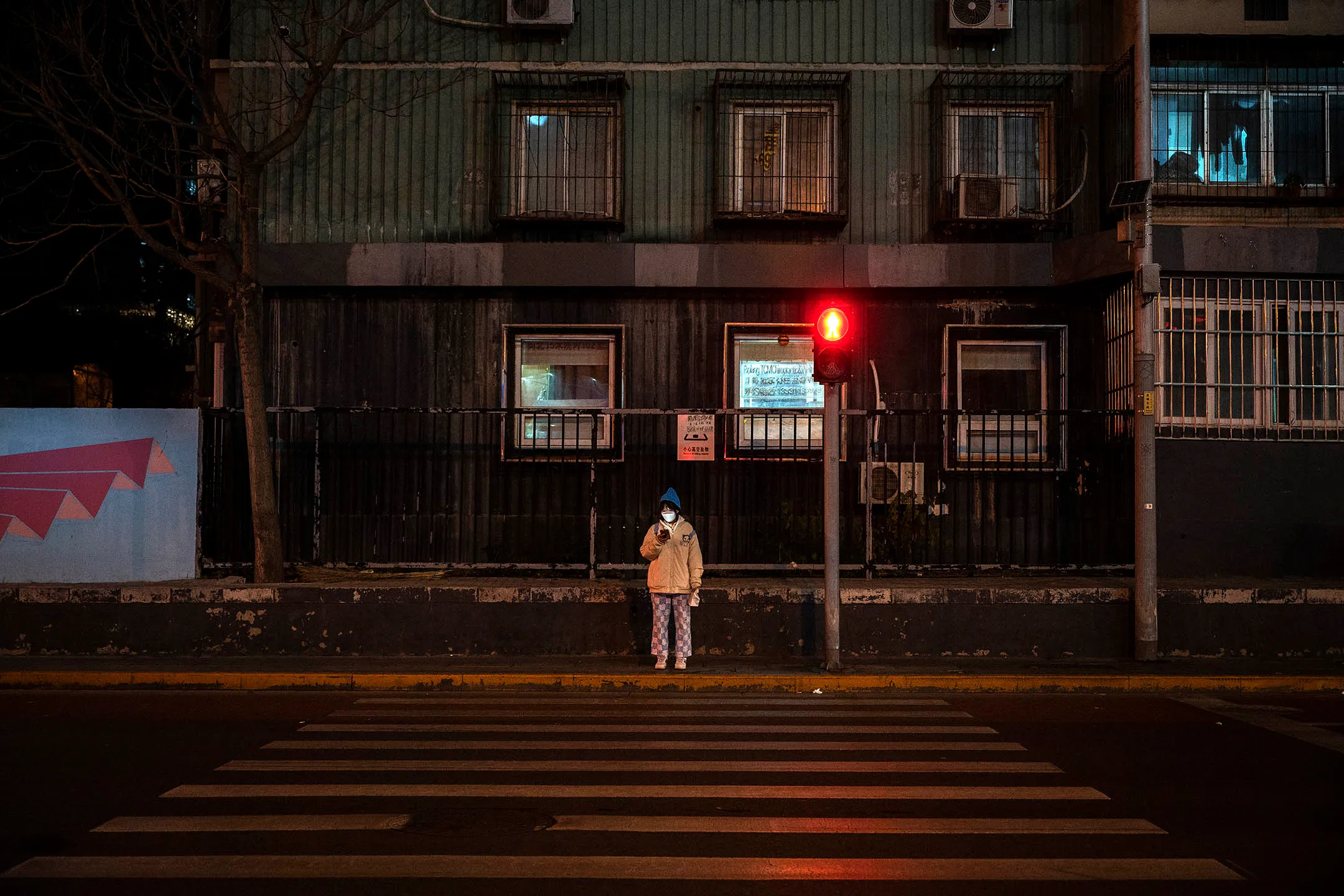 2022年11月22日，北京，一名婦女走過一條空無一人的道路。攝：Kevin Frayer/Getty Images