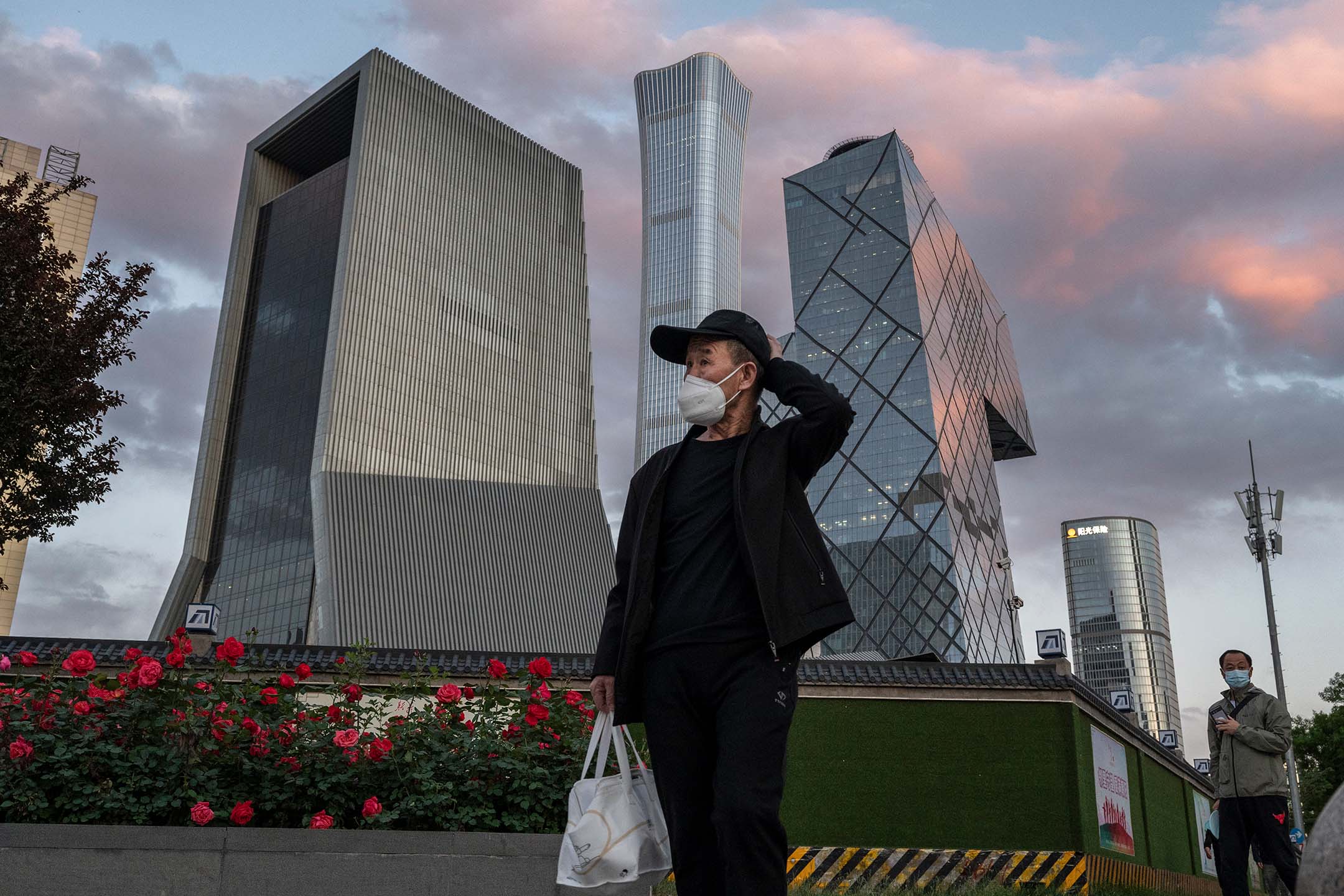 2022年5月12日，中国北京，一名男子在中央商务区前经过。摄：Kevin Frayer/Getty Images