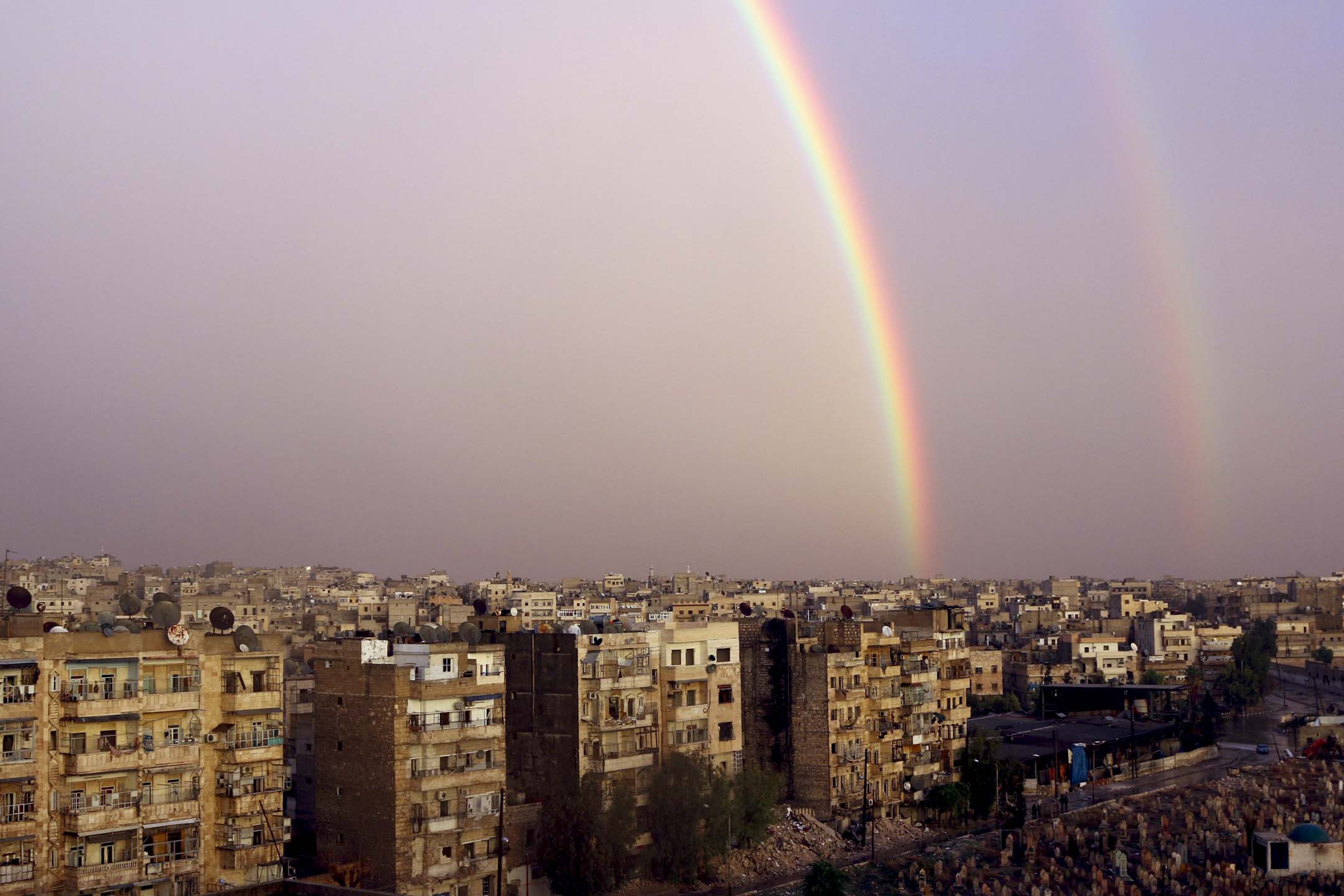 2014年11月21日，叙利亚阿勒颇，受损的建筑物上空出现双彩虹摄：Mahmoud Hebbo/Reuters/达志影像