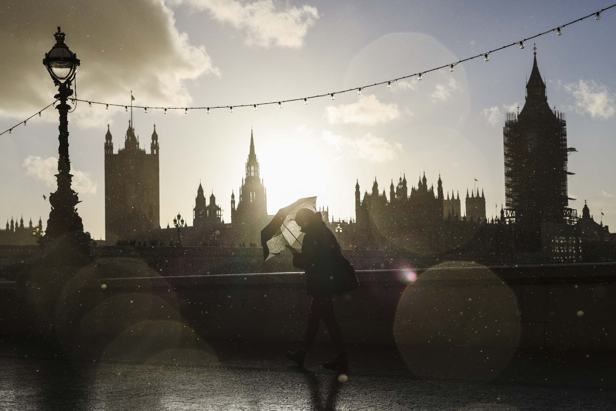 2021年10月31日，英国伦敦，一名行人在雨中沿著南岸行走。摄：Hollie Adams/Getty Images