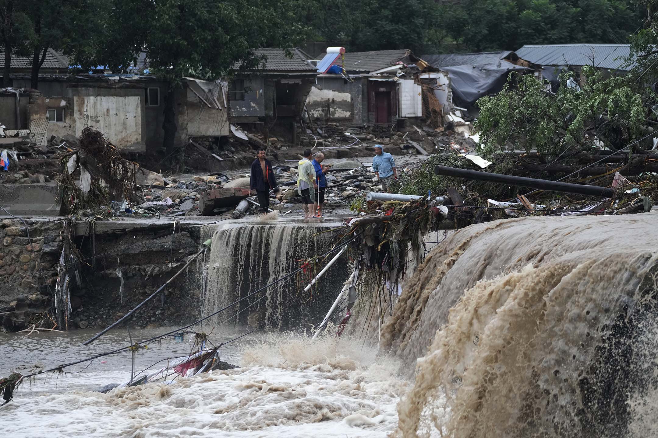 2023年7月31日，北京，连续降雨引发警报，村民聚集在被洪水破坏的村庄附近。摄：Andy Wong/AP/达志影像