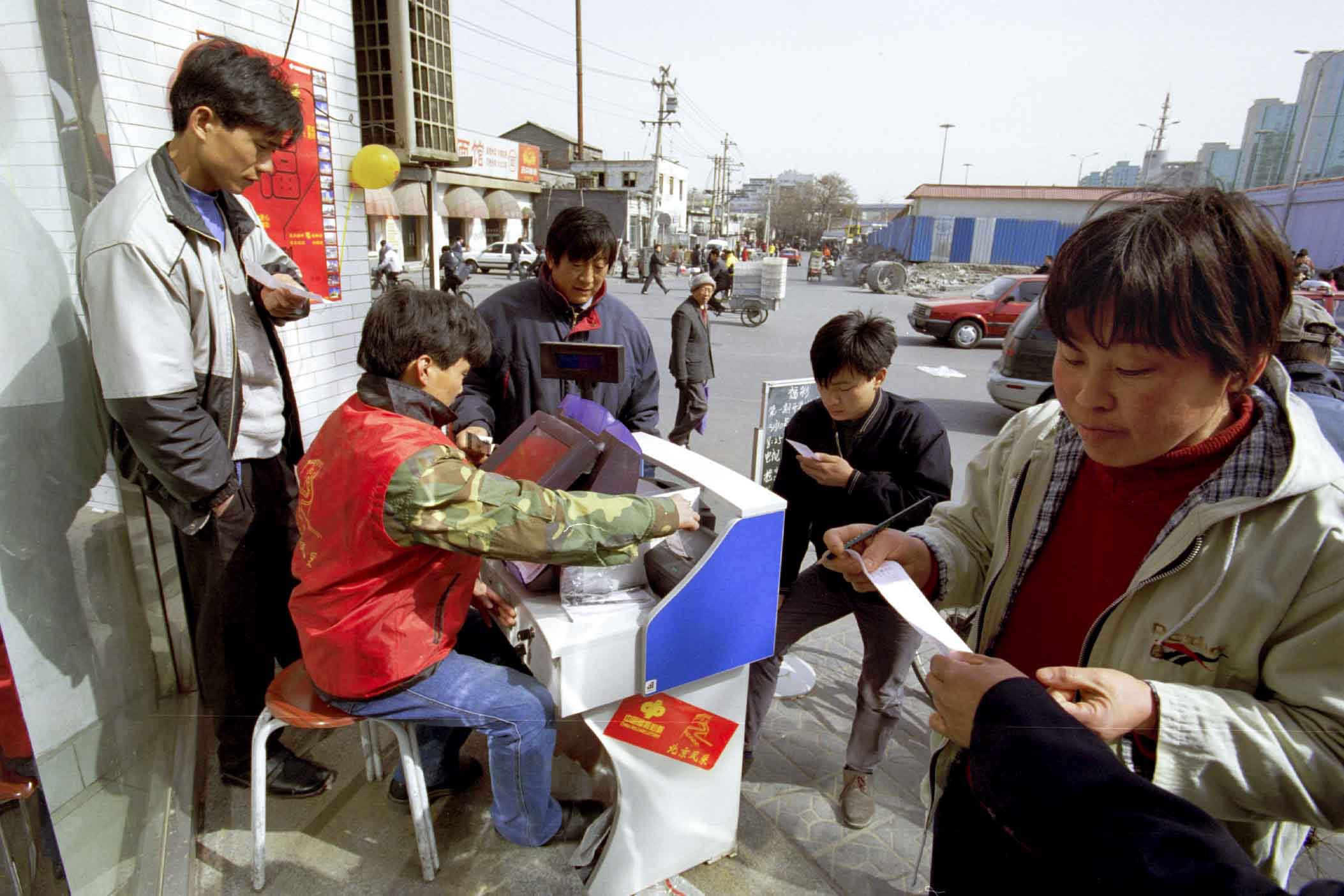 数名市民在街上的路摊购买彩票。摄： Peter Rogers/Liaison via via Getty Images