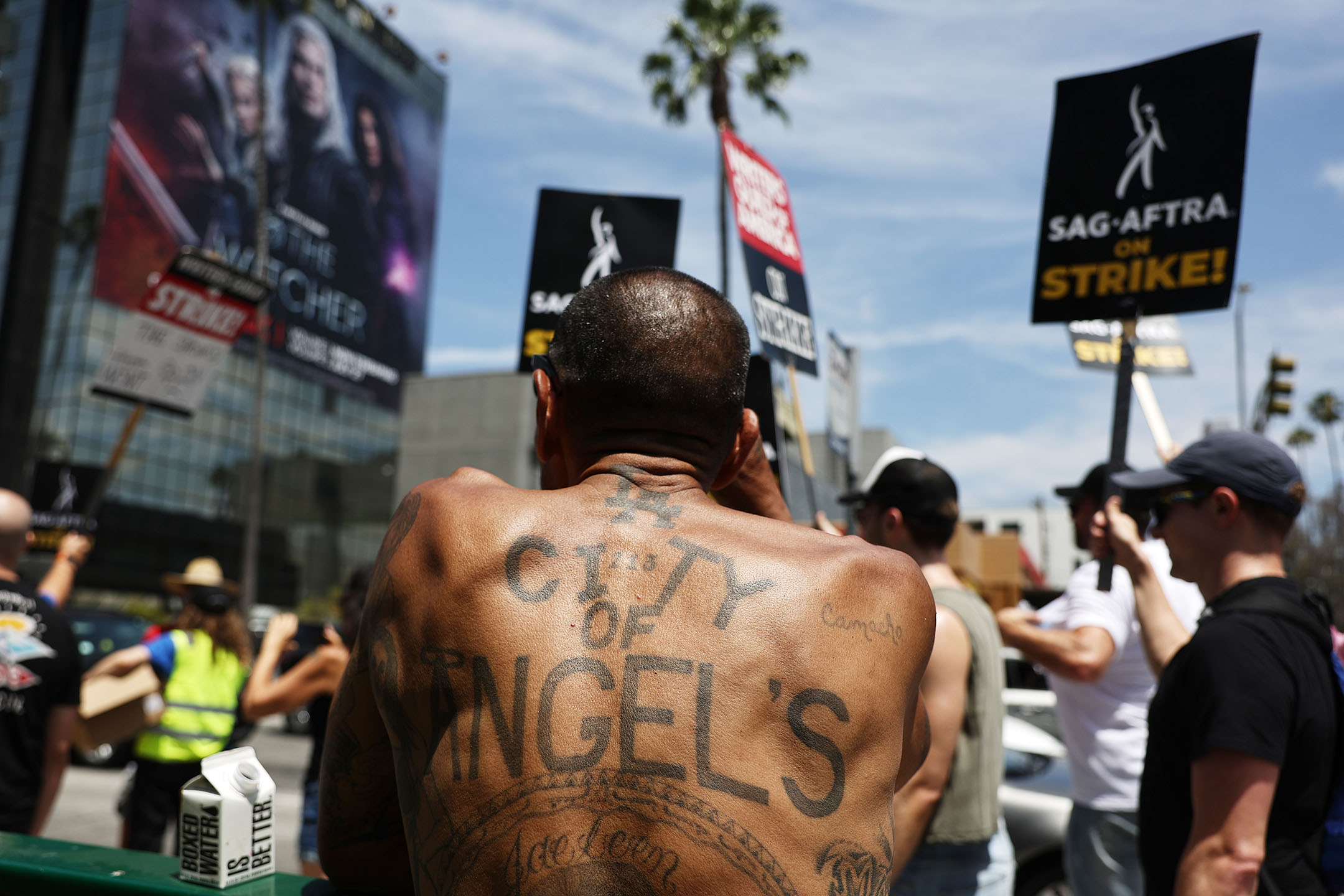 2023年7月21日，美国洛杉矶，一名男子在Netflix总部外观看游行队伍。摄：Mario Tama/Getty Images