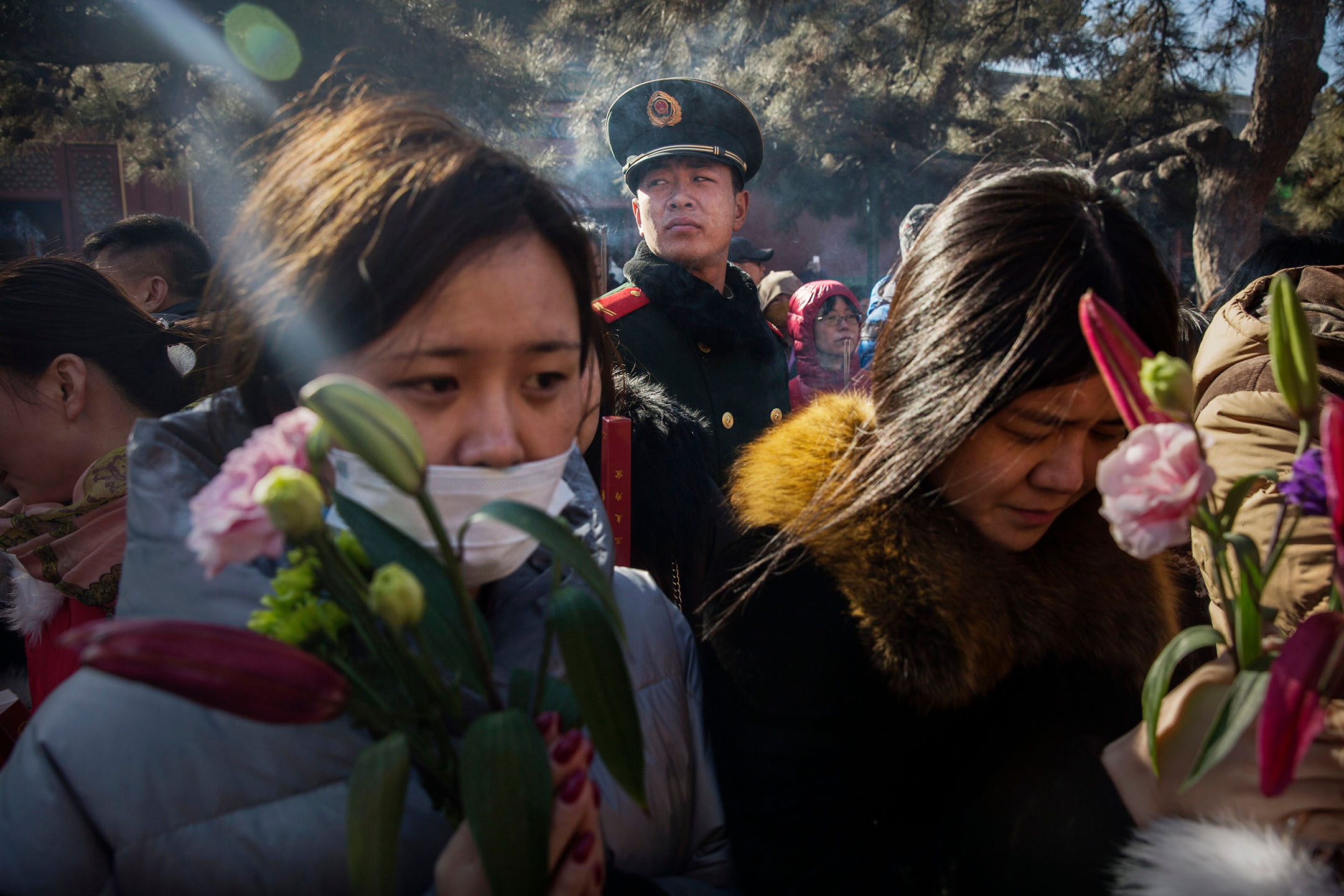 2016年2月8日，中国北京，一名公安在监视著祈祷中的中国信徒。摄：Kevin Frayer/Getty Images