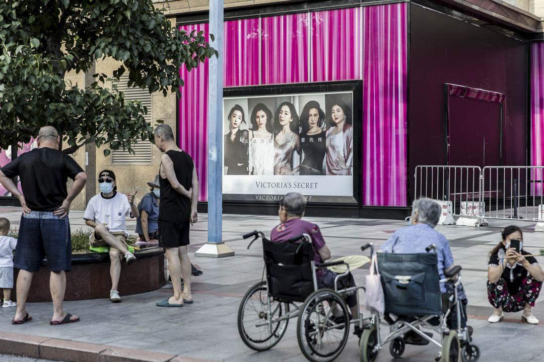 2021年8月25日，中国北京，居民在一家高档购物中心附近聊天。摄：Qilai Shen/Bloomberg via Getty Images