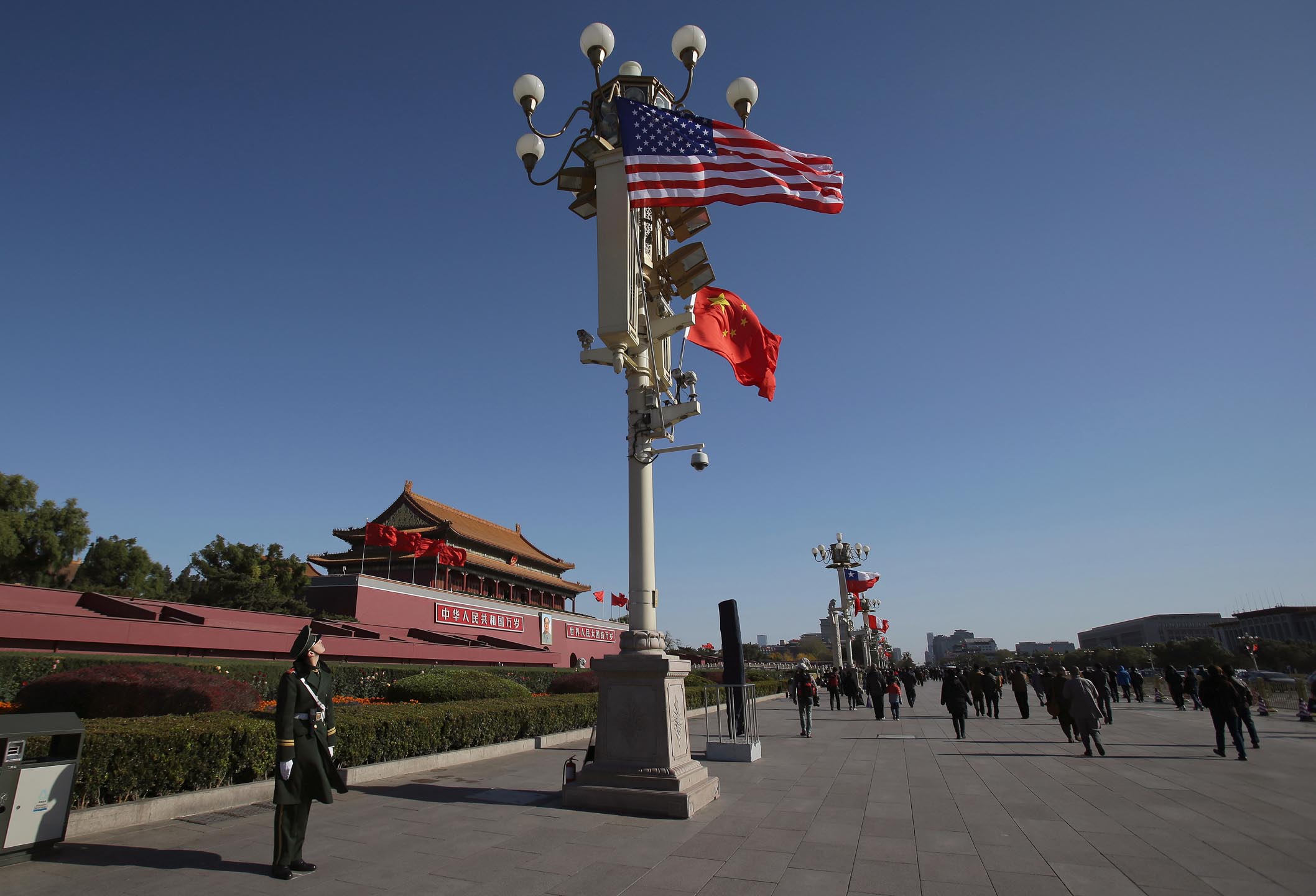 2014年11月12日，中国北京，一名军人看著旗杆上的国旗及美国国旗。摄：Aaron Favila/AP/达志影像