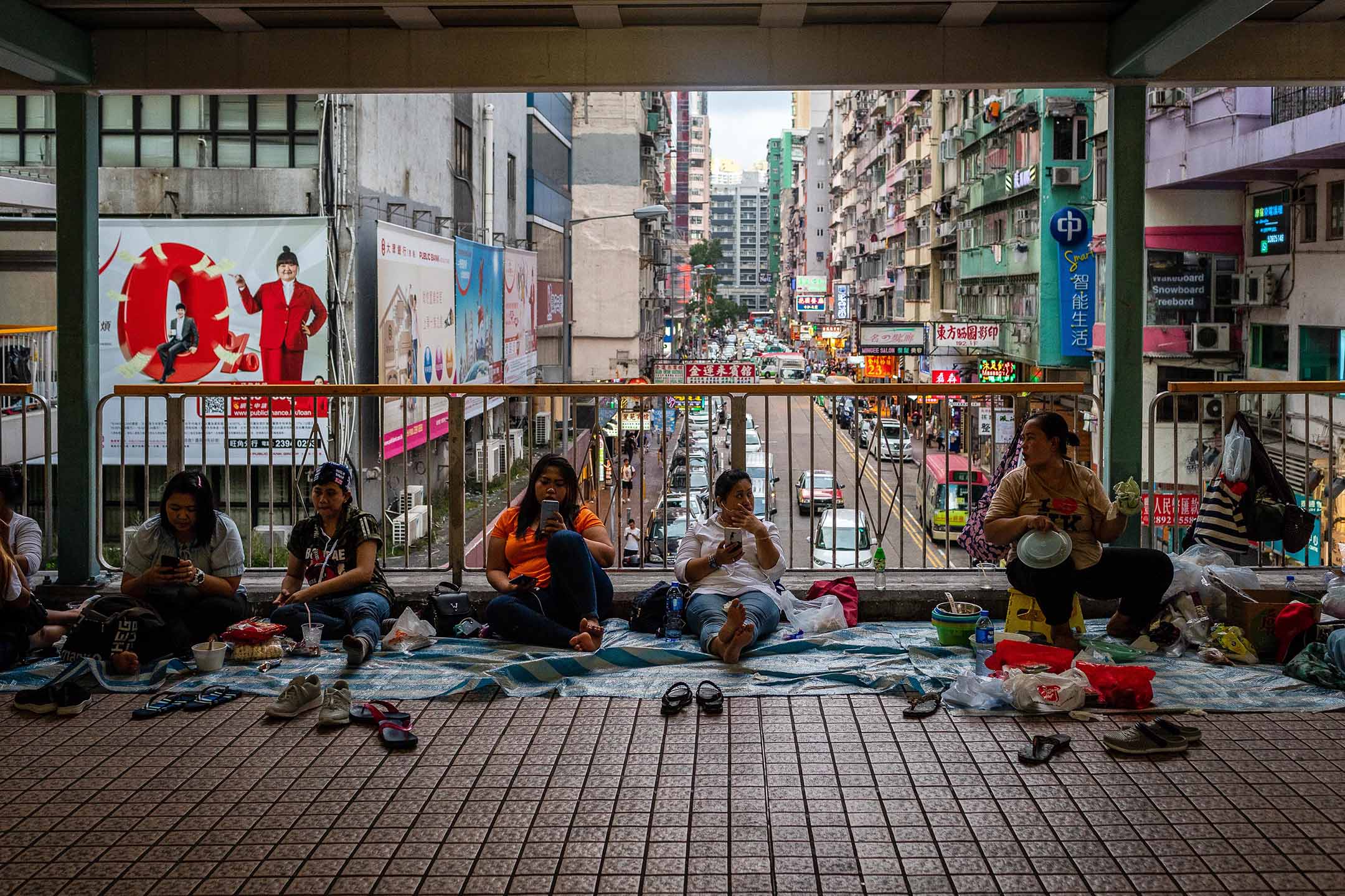 2019年6月22日，香港，外佣坐在旺角行人天桥上。摄：Eduardo Leal/Bloomberg via Getty Images