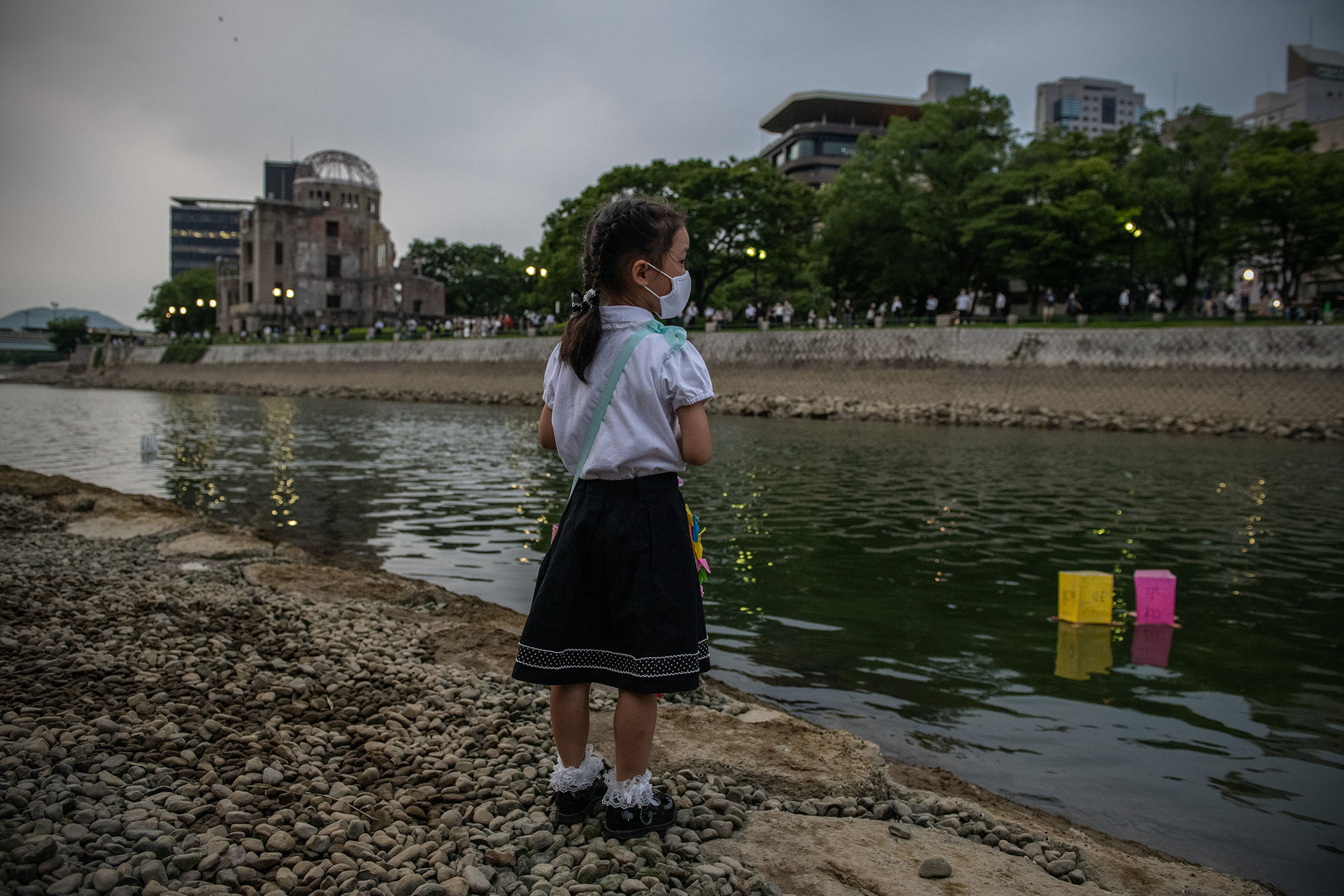 2020年8月6日，一名小女孩站岸邊，看著河上漂浮的燈籠。攝：Carl Court/Getty Images