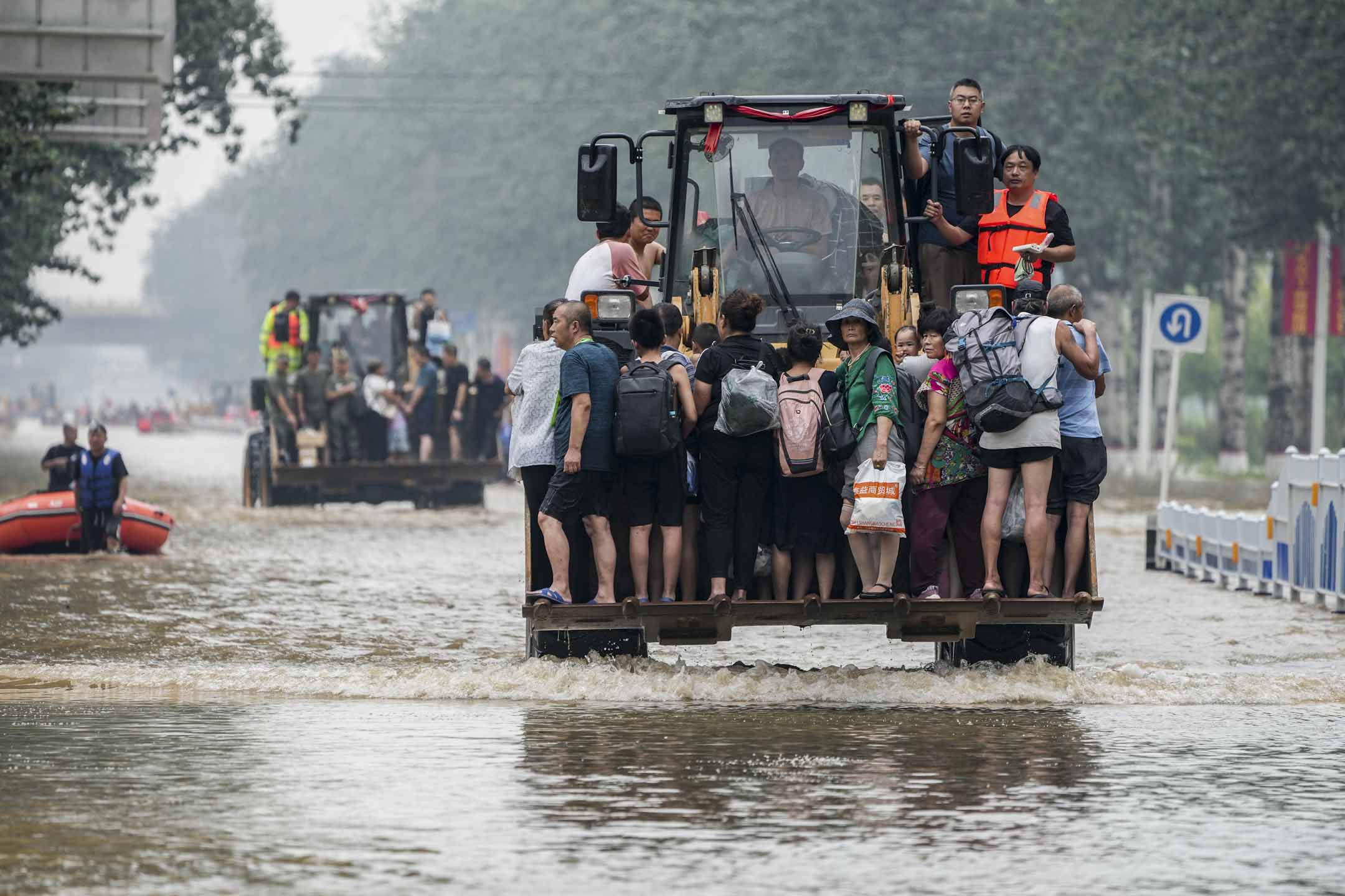 2023年8月2日，中国河北涿州连日倾盆大雨，救援人员使用前置装载机转移被困市民。摄：Cui Nan/China News Service/VCG via Getty Images