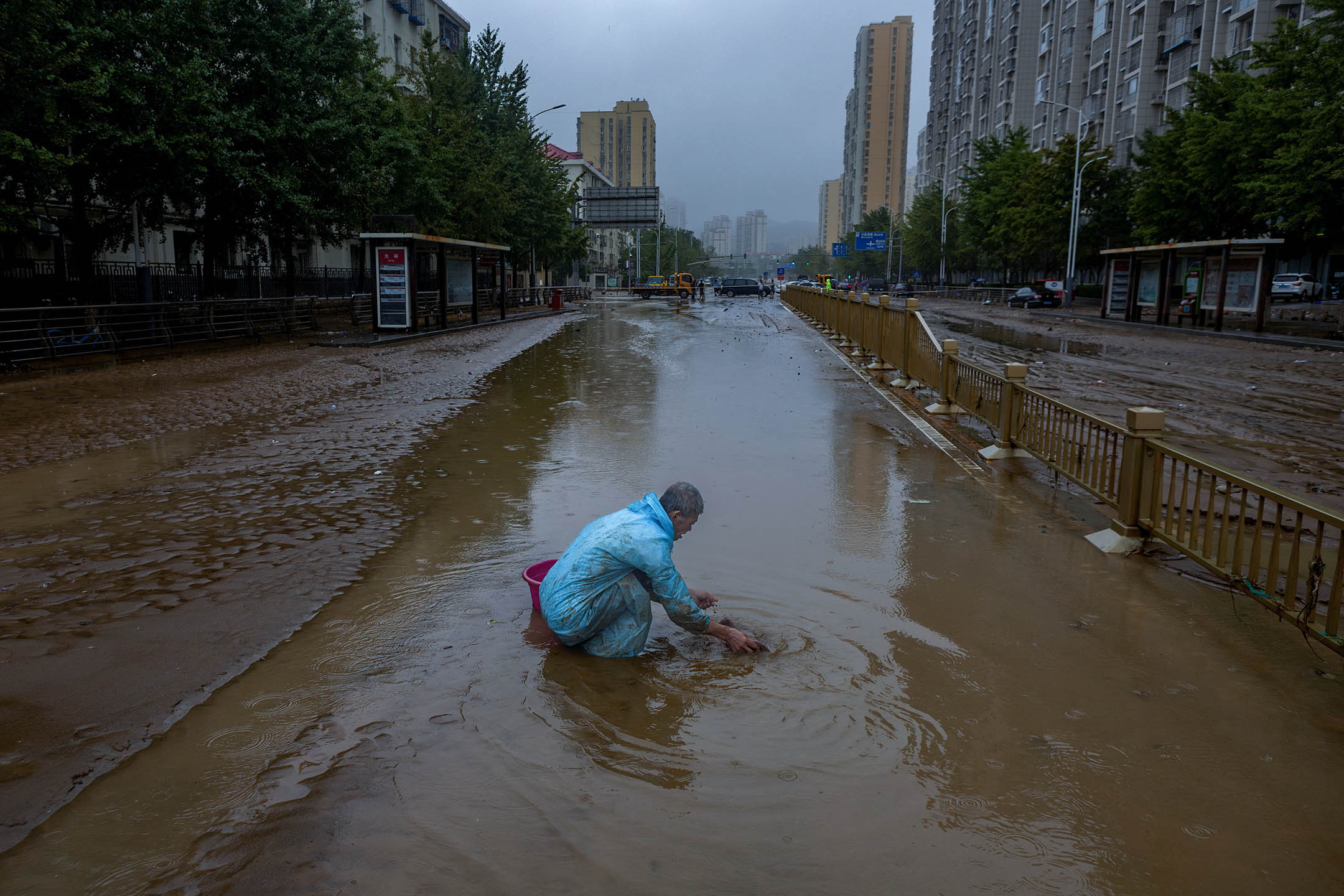 2023年8月1日，北京，一名男子在一条被洪水淹没的街道上。摄：Thomas Peter/Reuters/达志影像