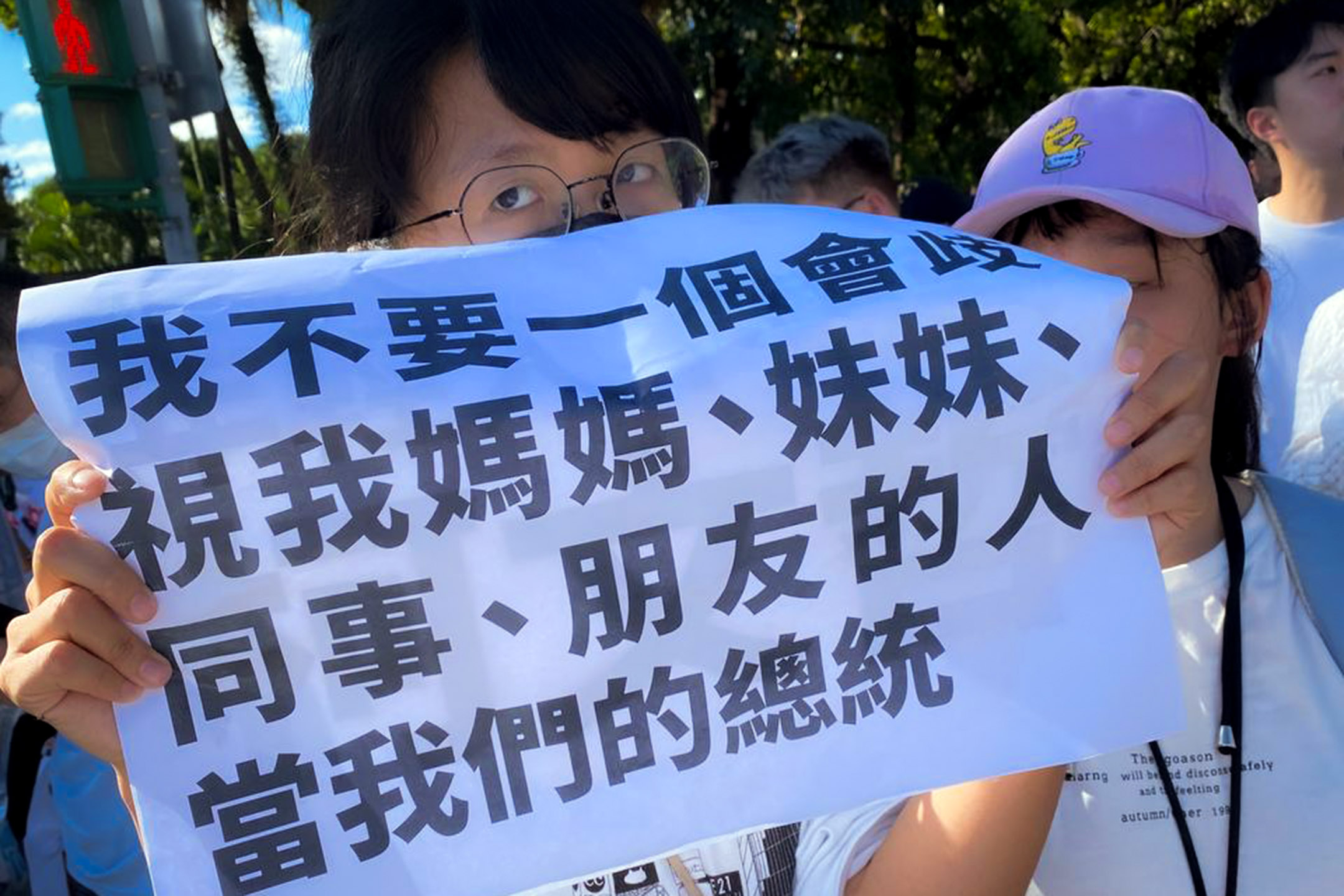 2023年7月16日，“公平正义救台湾”游行，阿楠手举著数张A3大小的白纸，上头印有“年轻人不需要柯文哲”、“我不要一个会歧视我妈妈、妹妹、同事、朋友的人当我们的总统”，以及柯文哲过去各种歧视女性的发言纪录。摄：许伯崧/端传媒