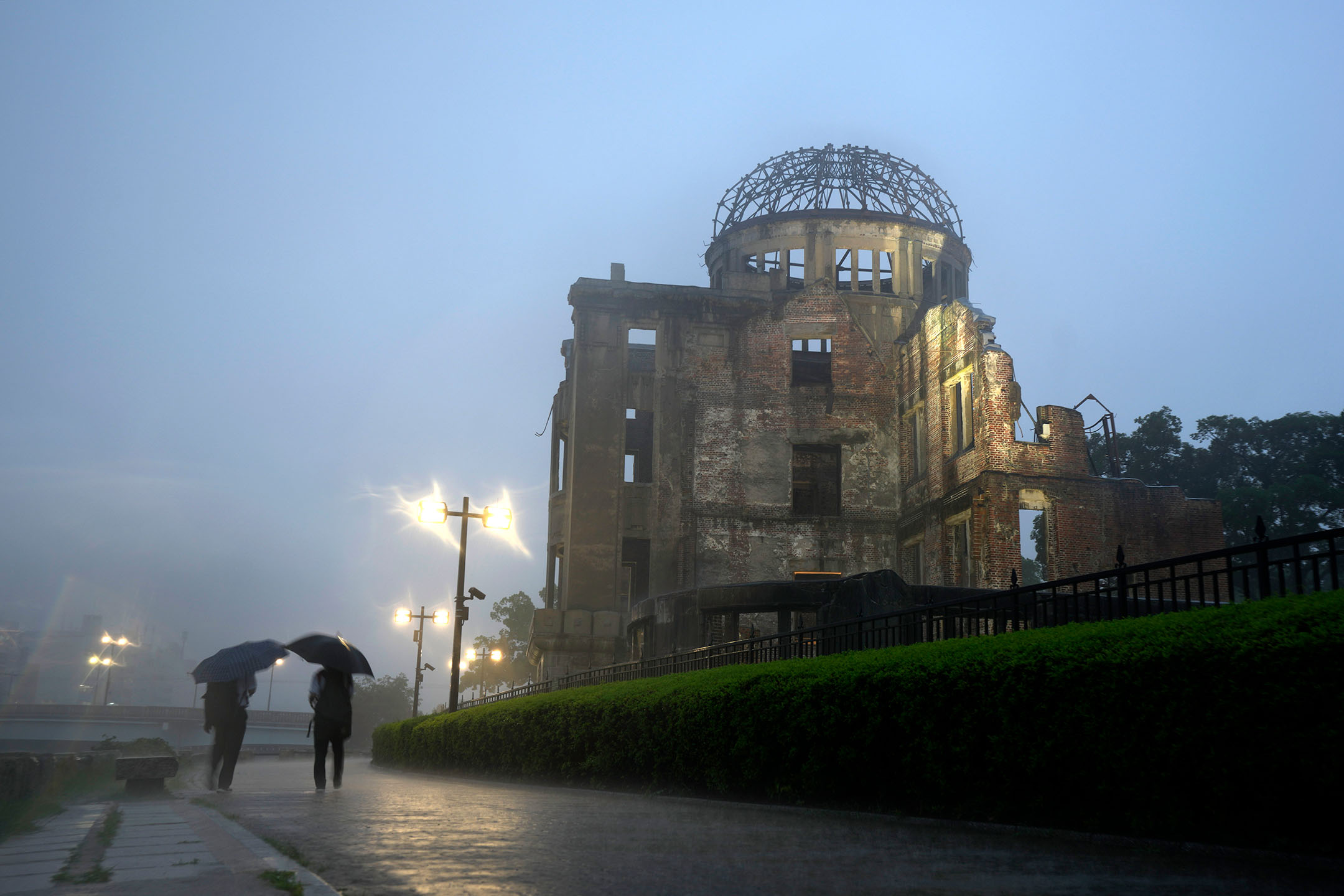 2021年7月15日，日本廣島，兩名男人在雨中行走。攝：Eugene Hoshiko/AP/達志影像