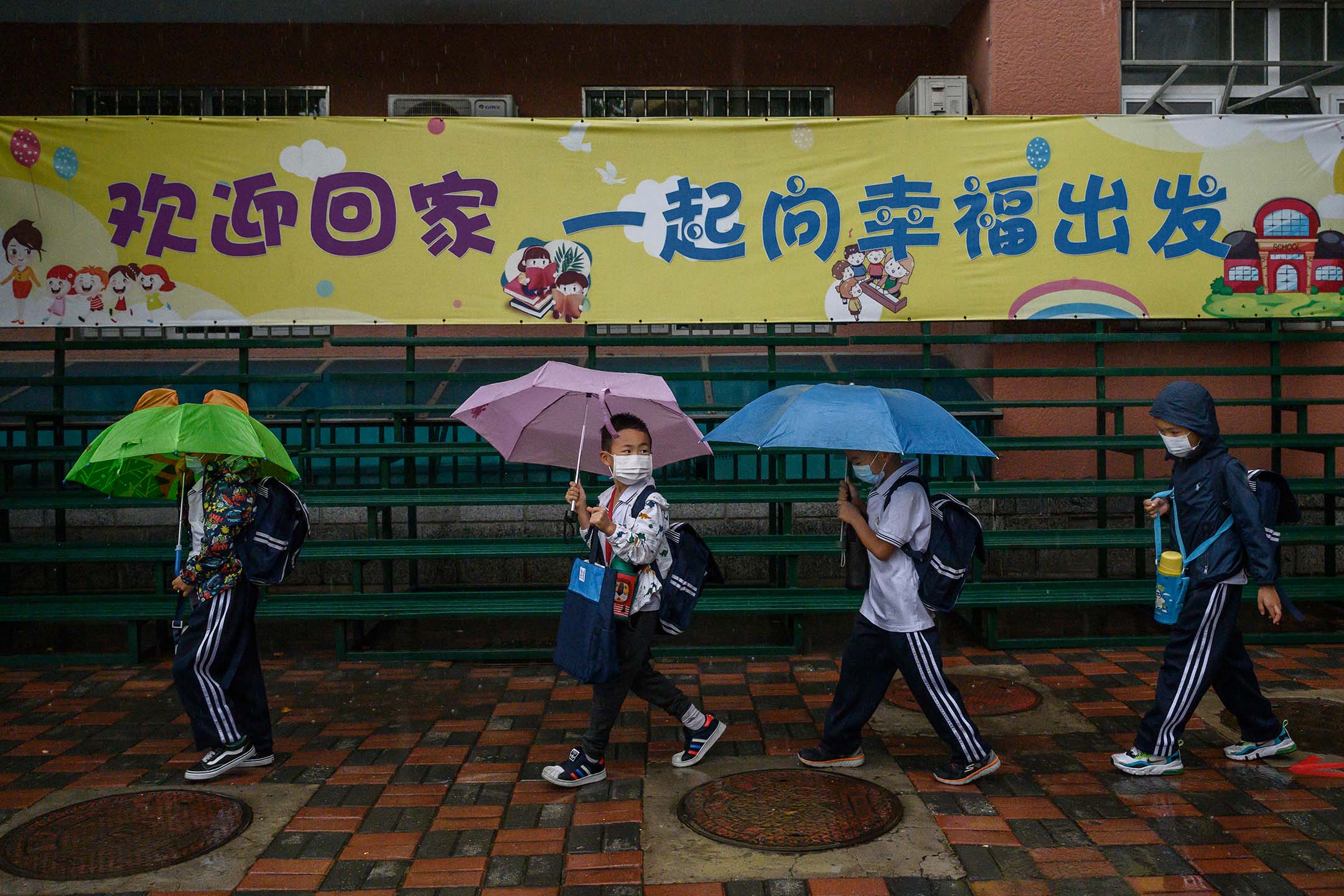  2020年9月23日，中国北京，学生们冒著大雨到学校上课。摄：Kevin Frayer/Getty Images