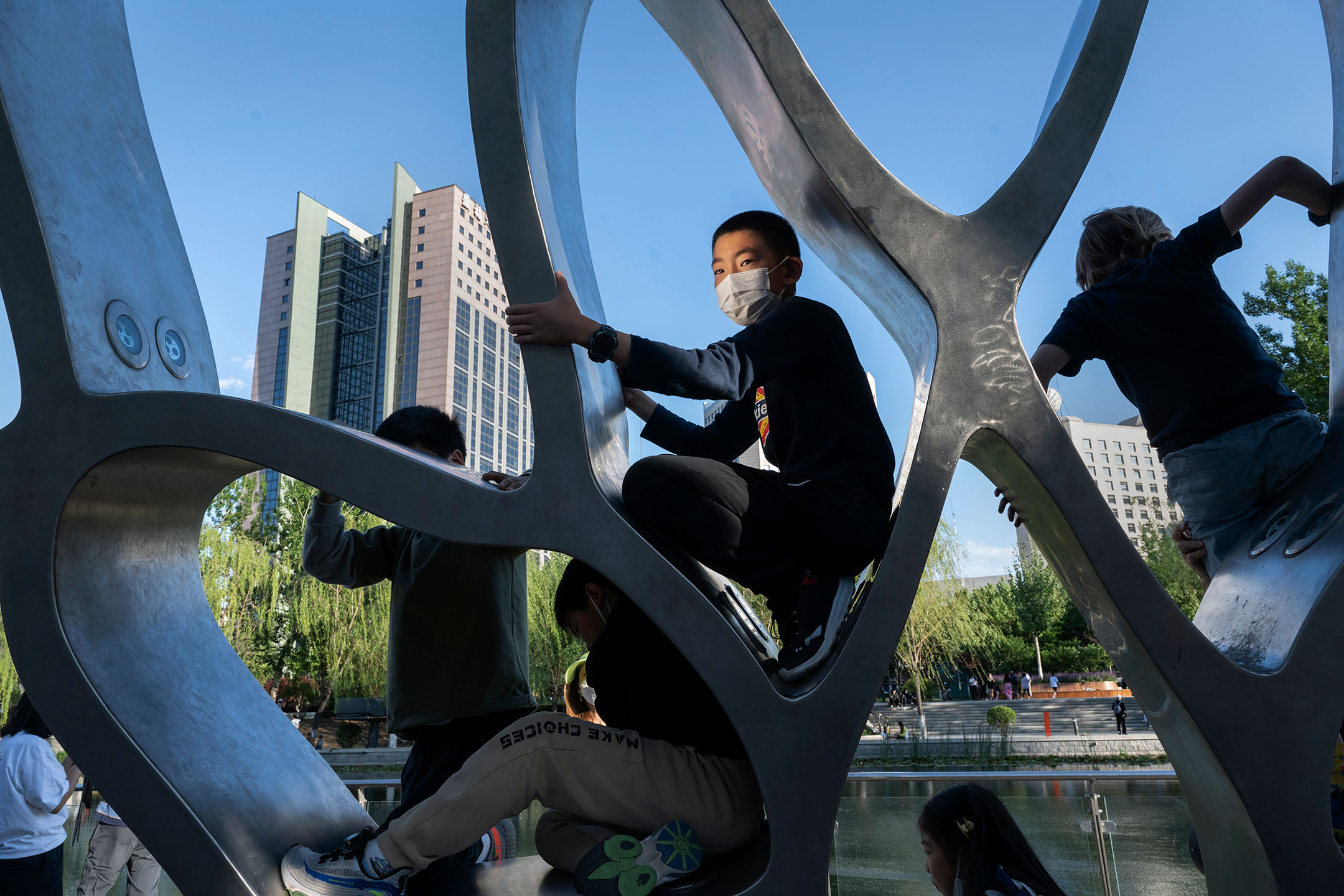 2022年5月14日，中國北京，孩子們在一座雕塑上玩耍。攝：Kevin Frayer/Getty Images