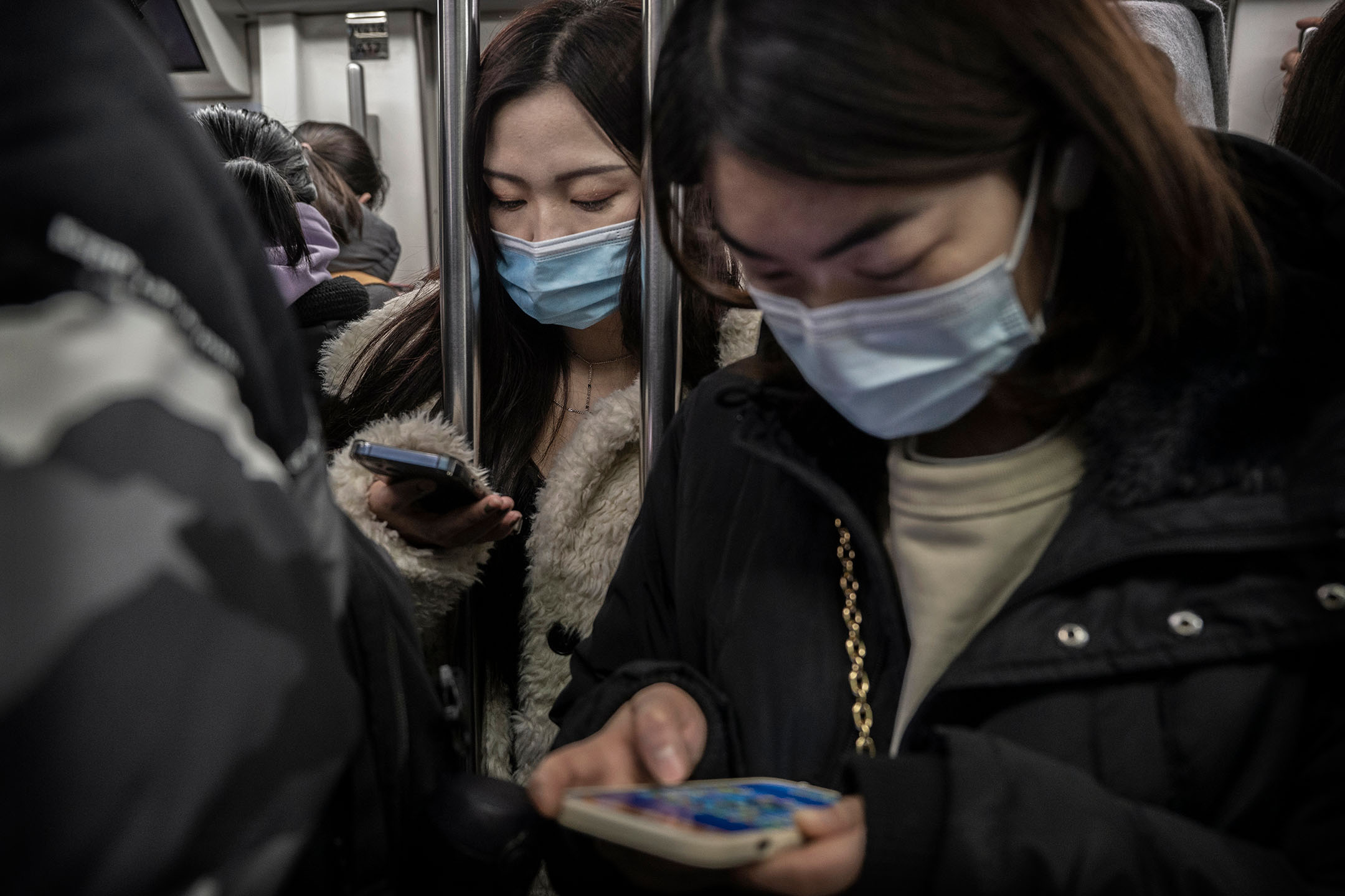 2022年1月13日，中国北京，女士在车厢内看手提电话。摄：Kevin Frayer/Getty Images