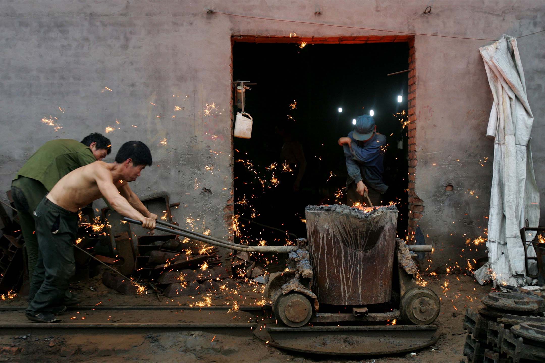 2006年8月30日，中国金州市，工人在铁器厂工作。摄：China Photos/Getty Images